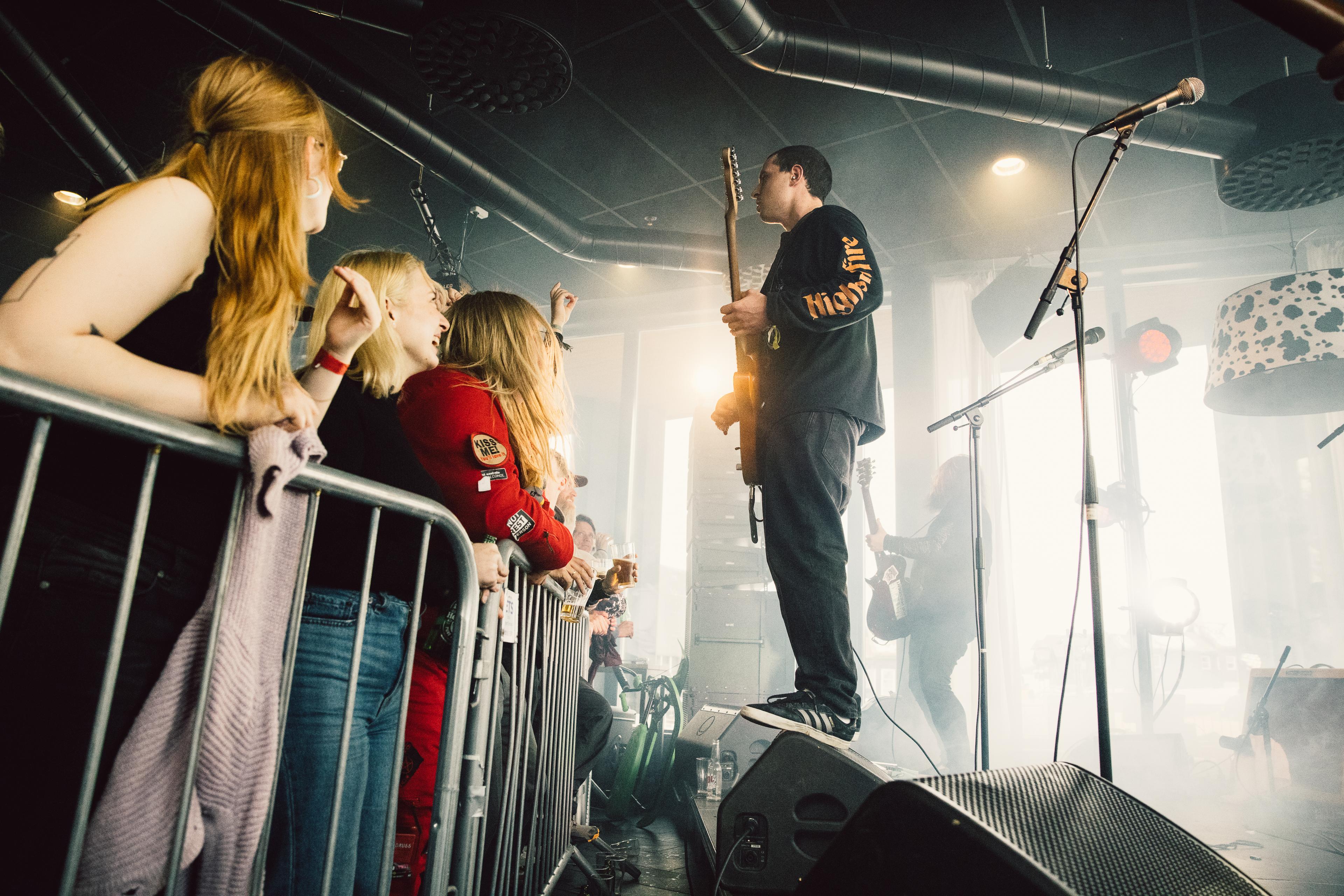 Guitarist stands on a stage and plays a concert in front of an audience