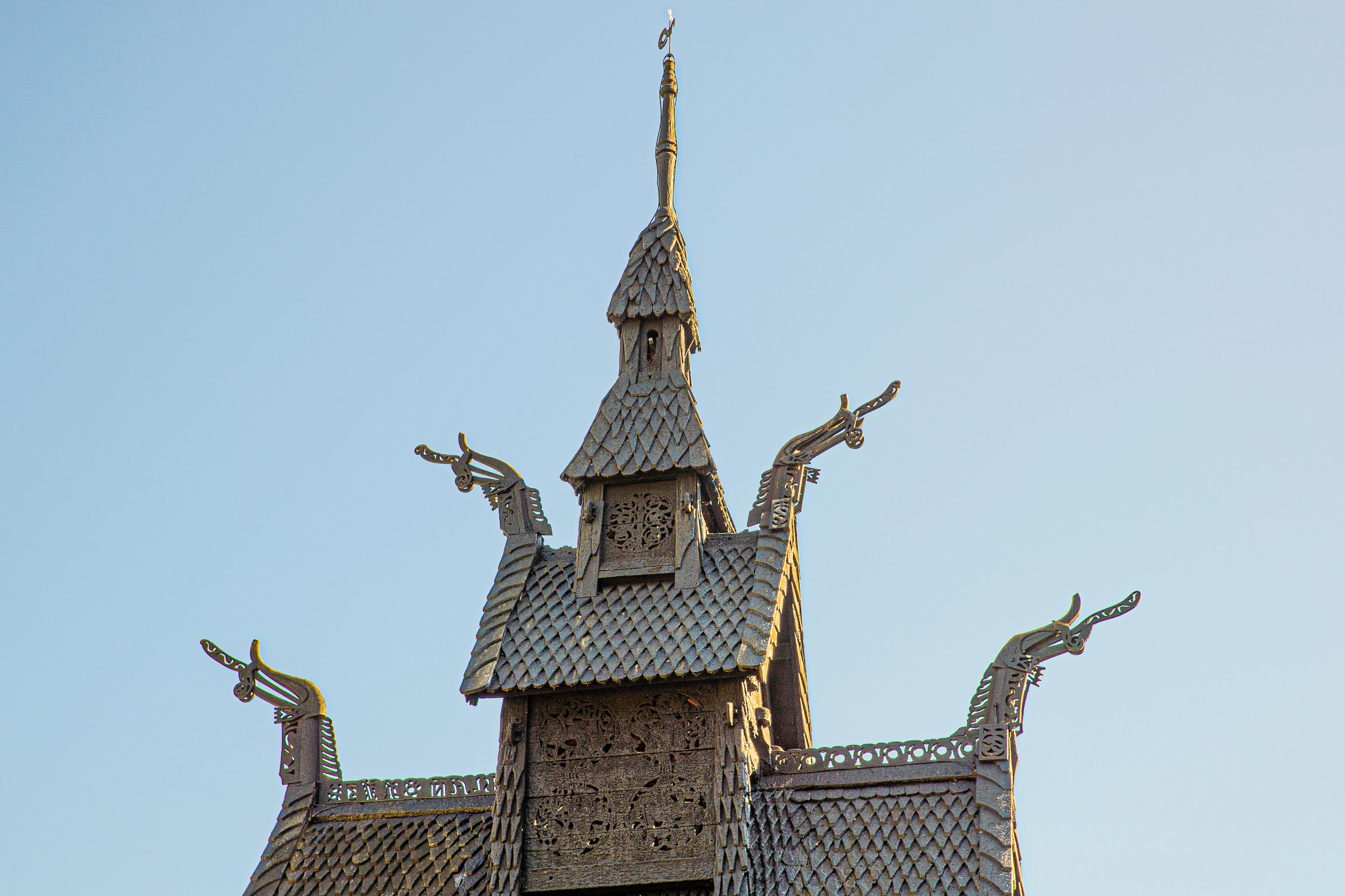 Nærbilde av dragehodene på kirkespirene til Borgund Stavkirke. 