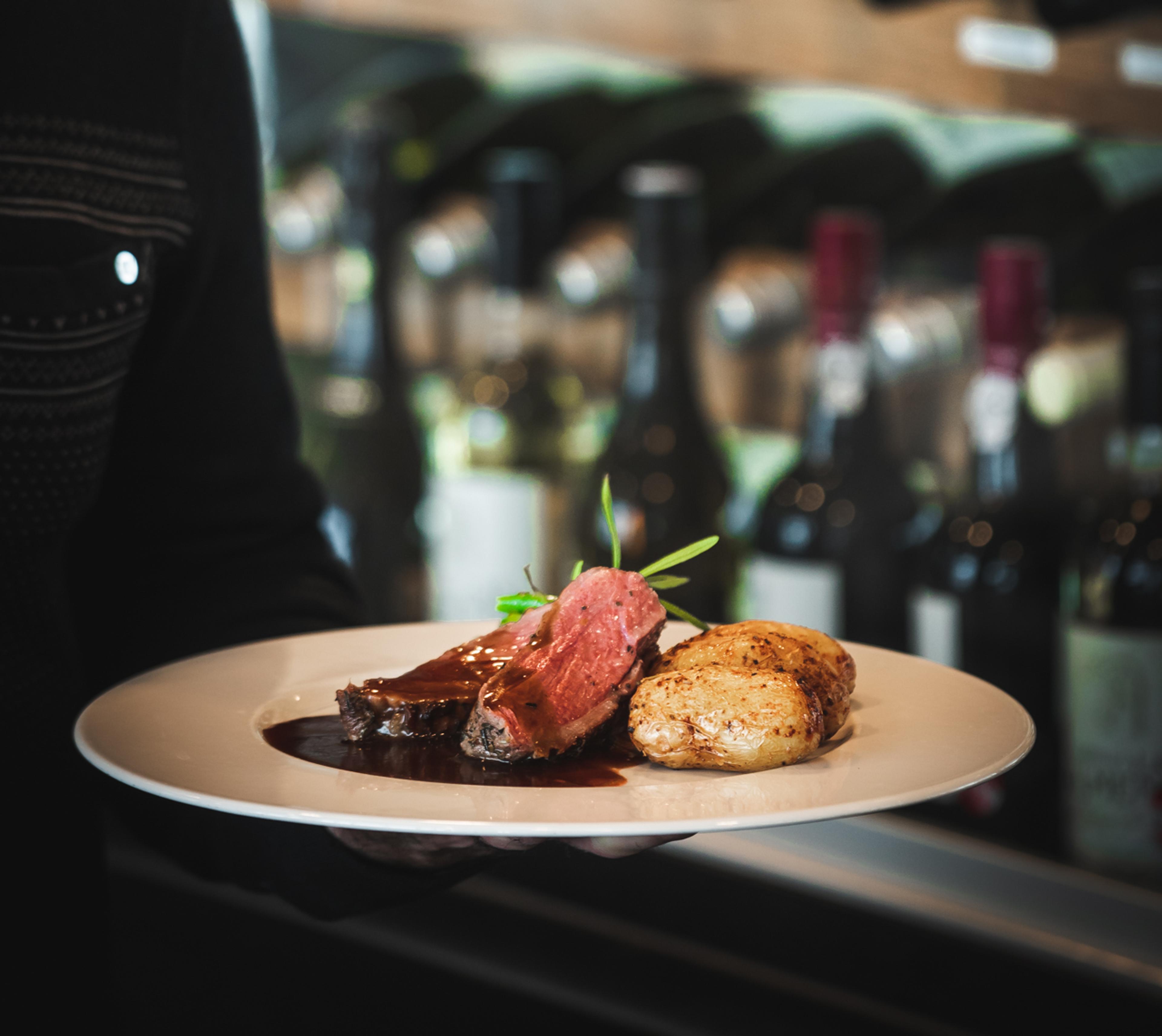 Biff servert med poteter og rødvinssaus på restaurant.