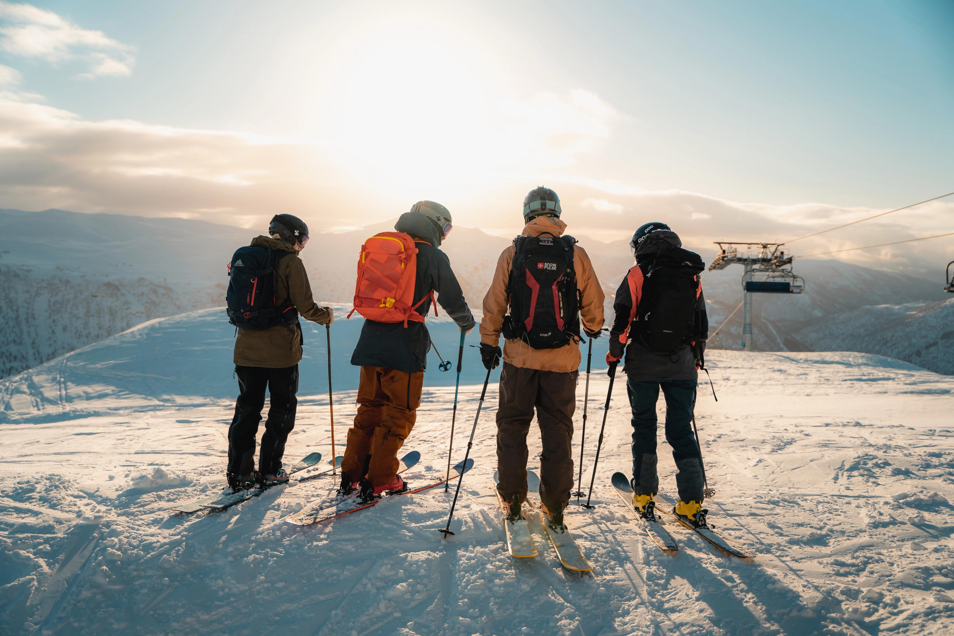 Fire skikjørere med skredsekker står klar for offpistekjøring i Myrkdalen.