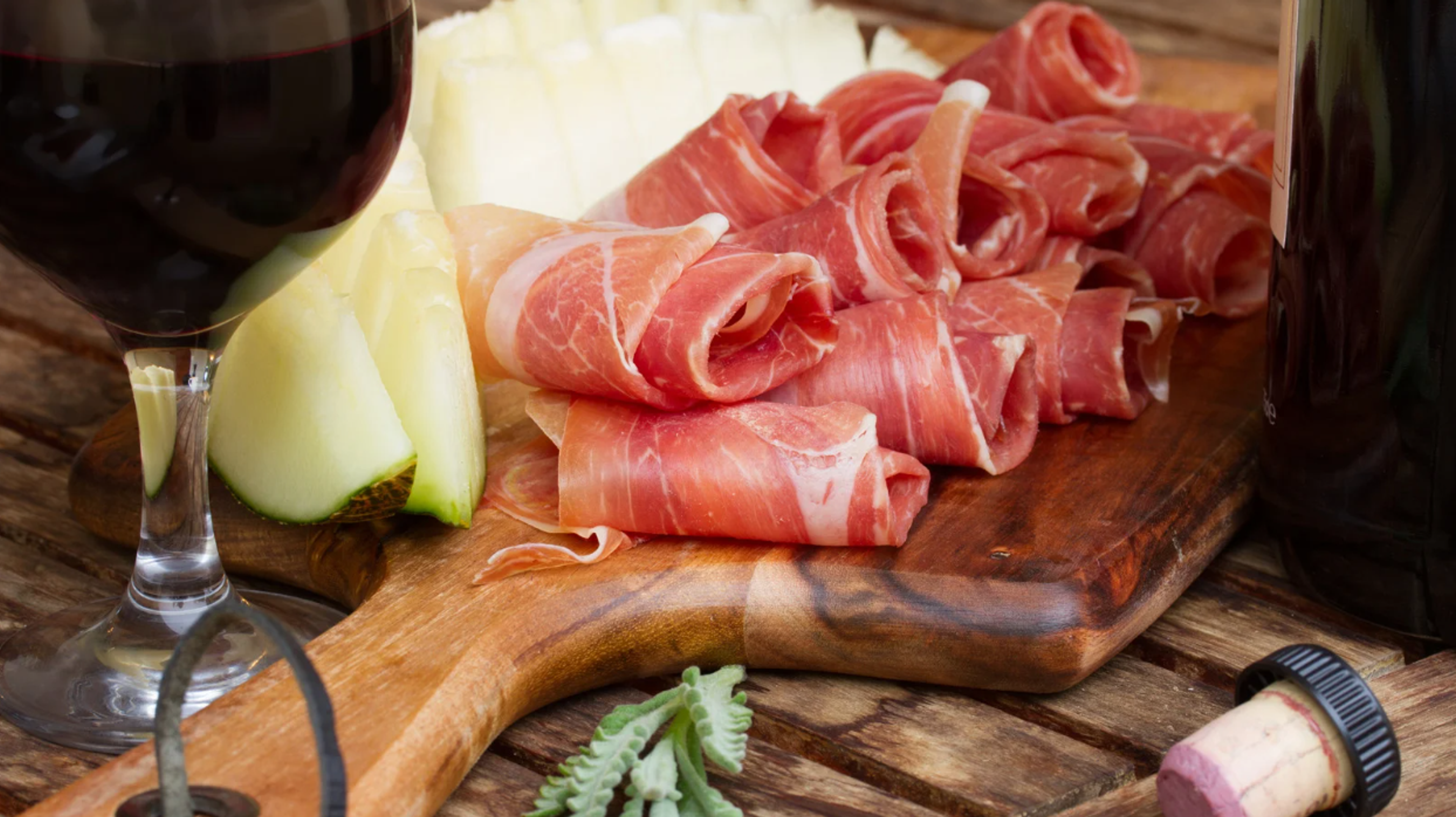 Ham and melon on a wooden board