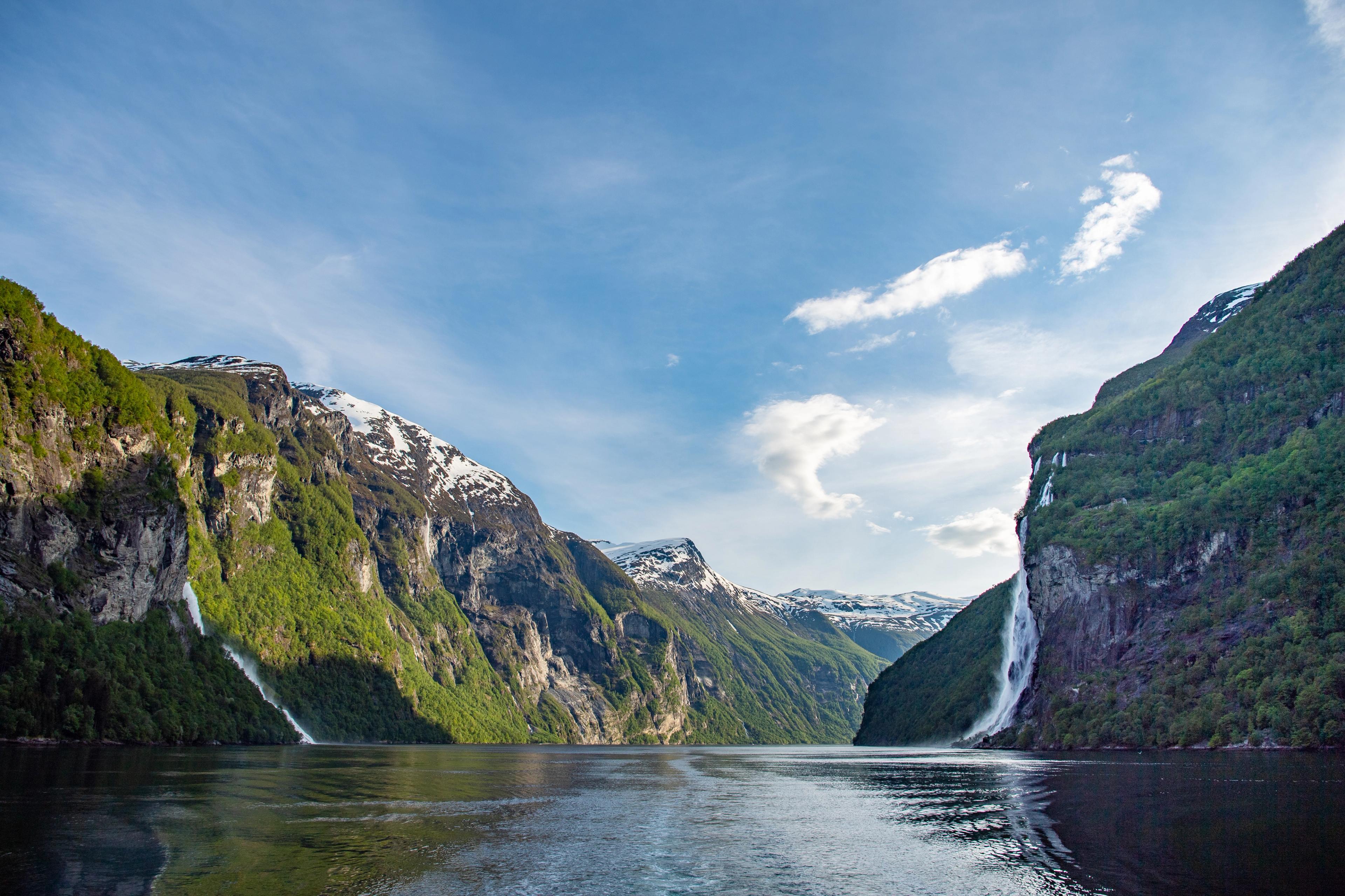 Scenic view of Geirangerfjord with waterfalls and towering mountains.