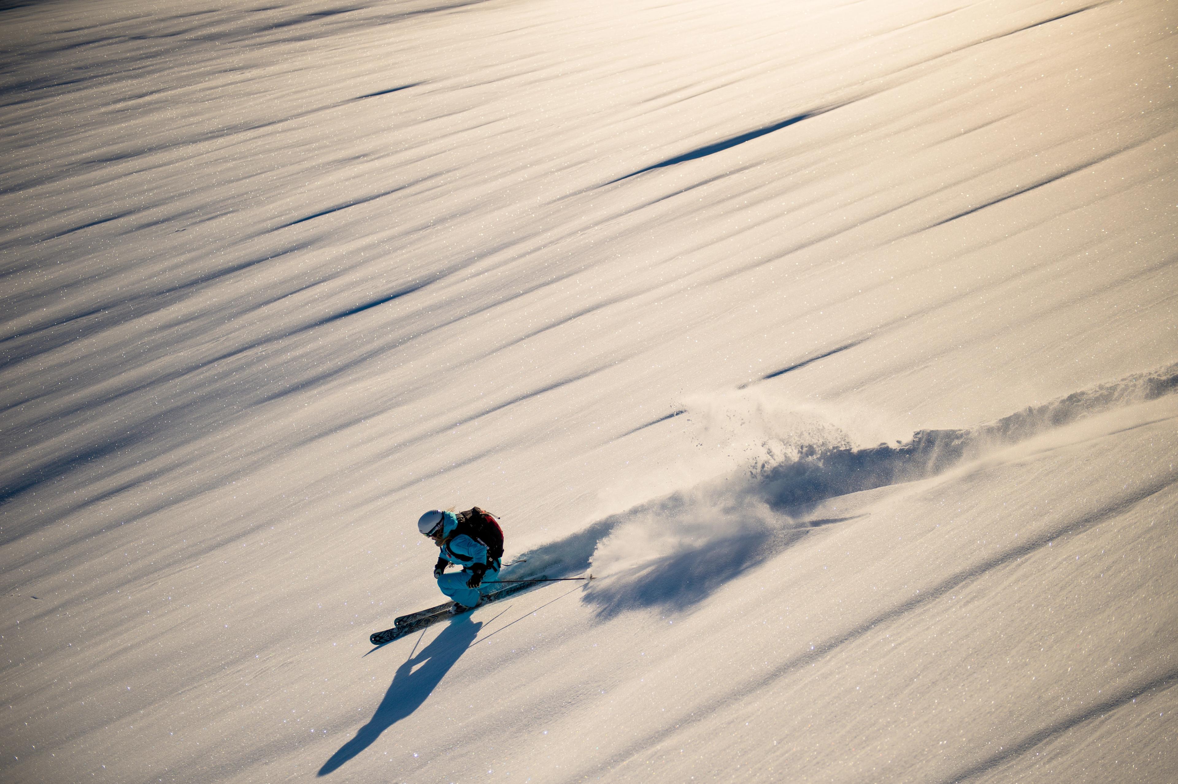 A skier makes a powder turn on a pristine mountainside.