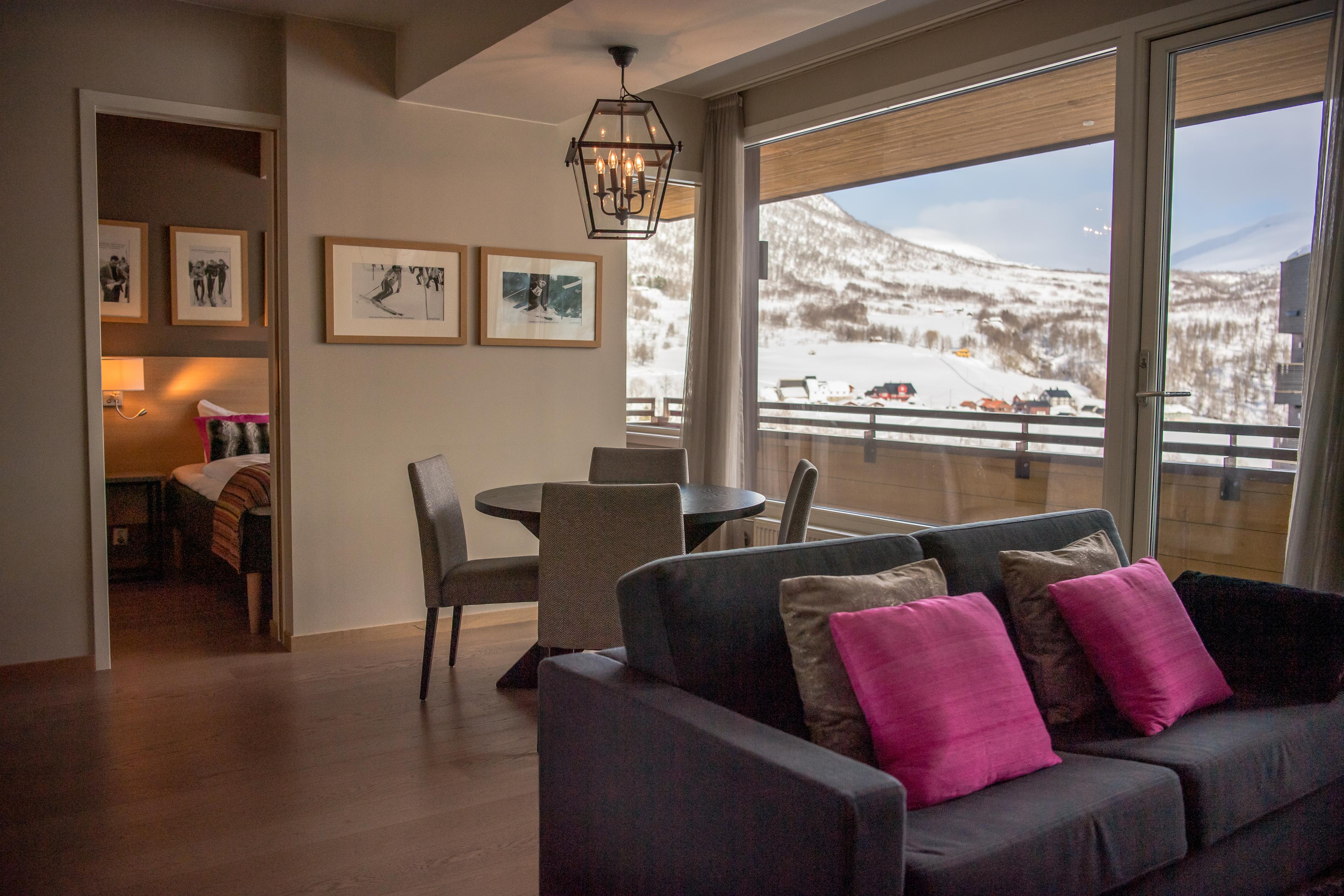 Hotellrom med separat soverom og stue, veranda og utsikt.