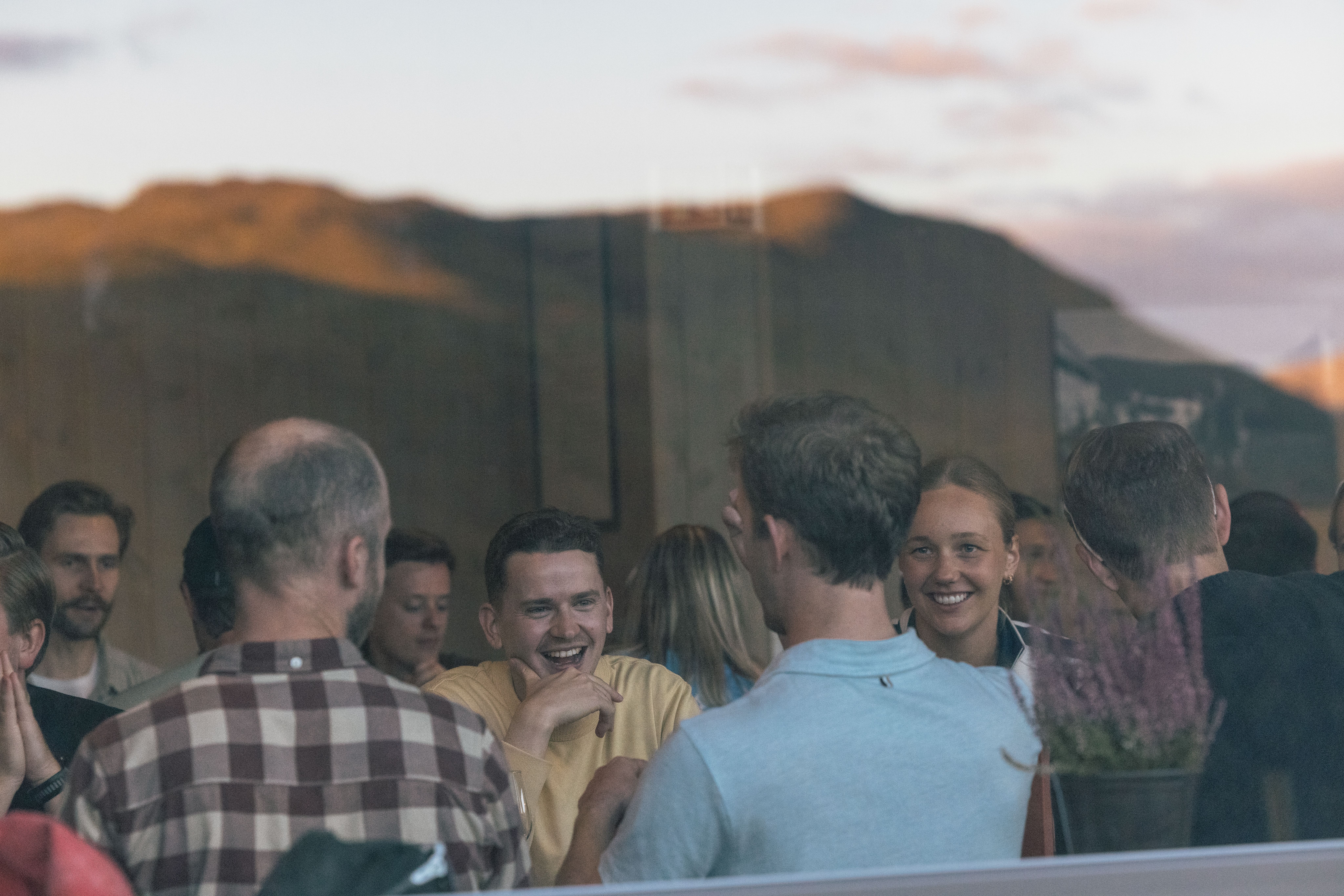 Folk sett smilende og pratende gjennom et vindu i Myrkdalen.