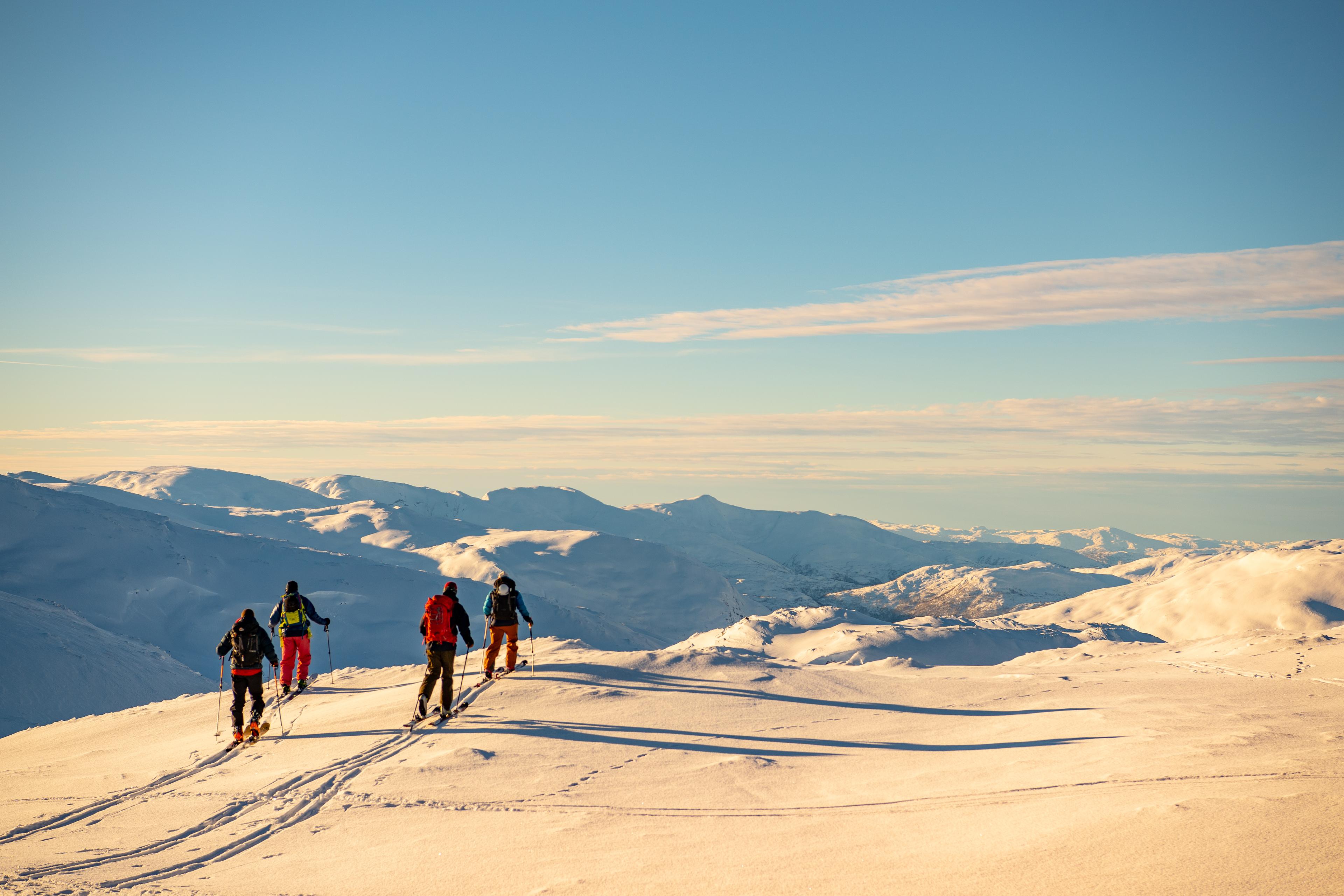 Et turfølge på fjellski har utsikt over fjelltoppene så langt øyet kan se.