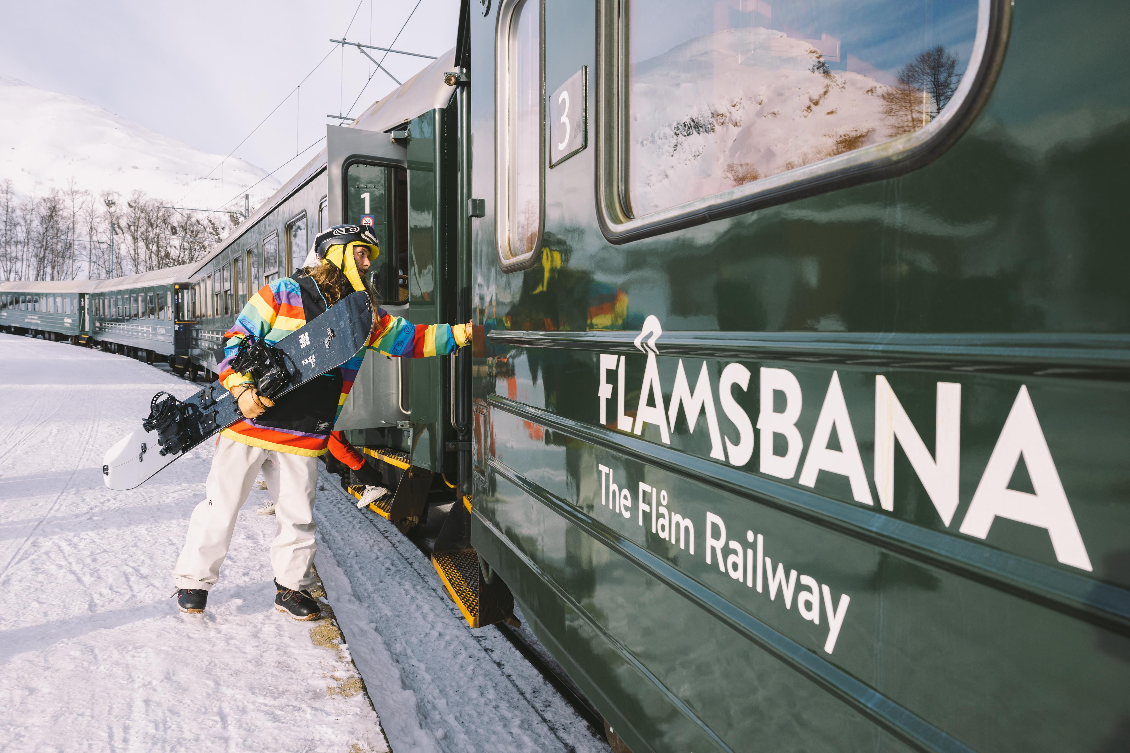 Snowboardkøyrar går om bord Flåmsbana ein vinterdag.