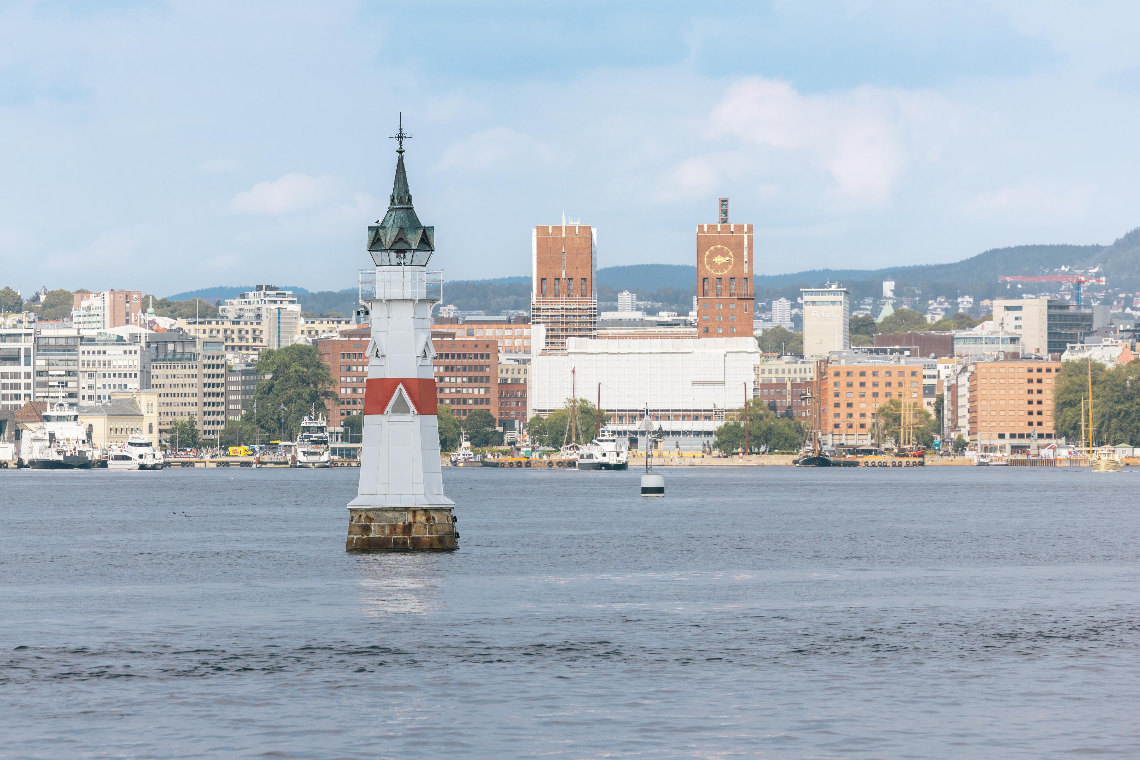 Utsikt fra fjorden mot Oslo Rådhus. Et lite fyr i forgrunnen.