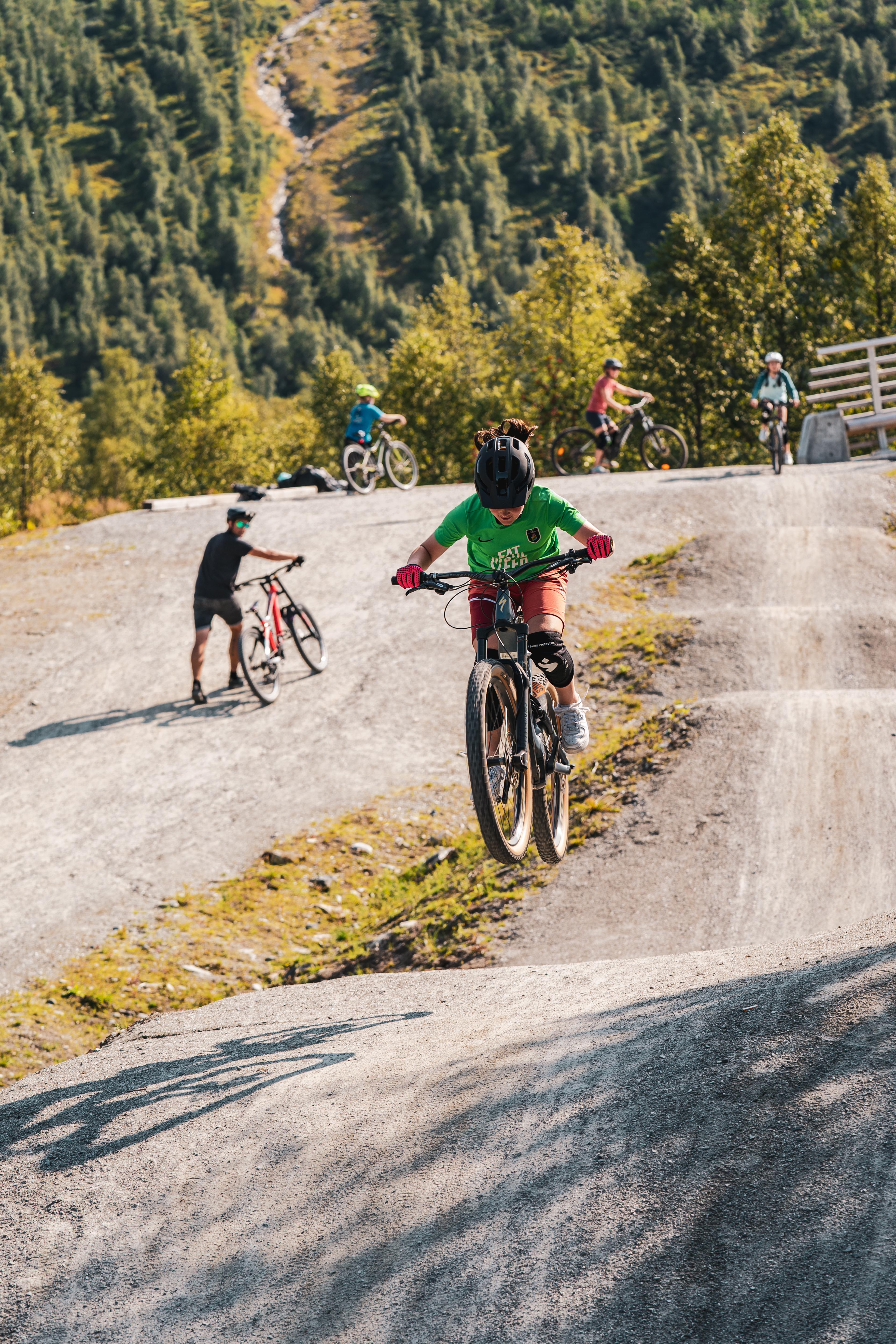 Children jump on bikes on the mountain bike trail.