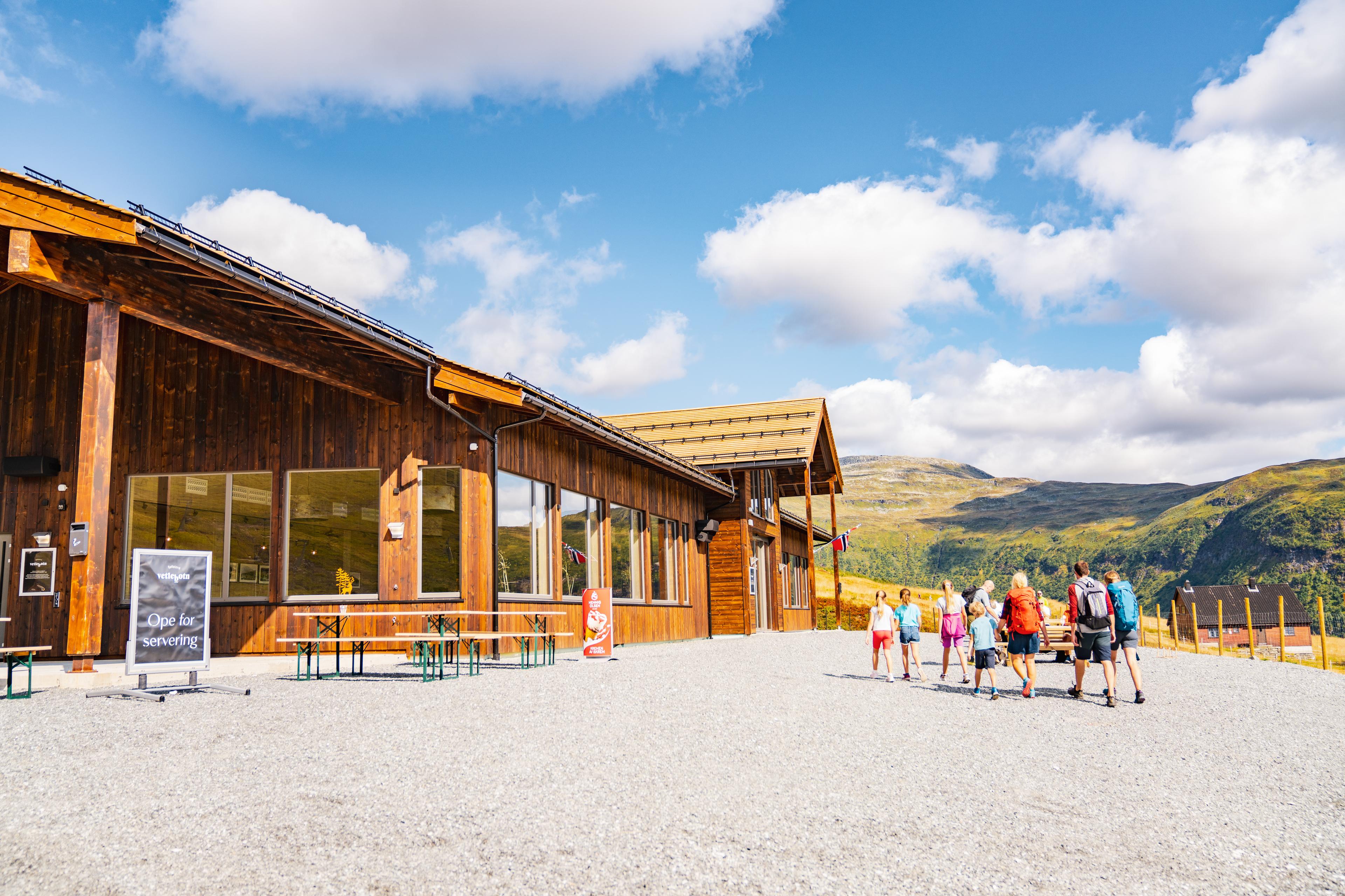 A tour group of adults and children arrives at the mountain stove for a bite to eat.