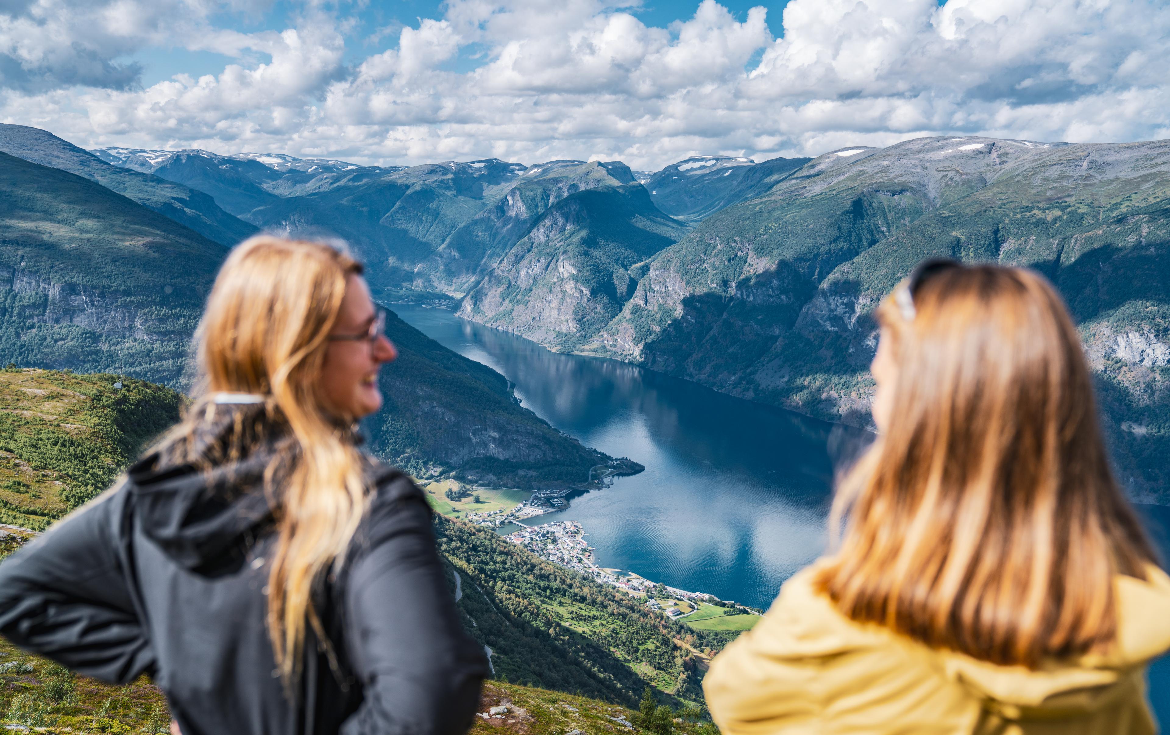 Two women looking over the fjord landscape from mt. Prest in Aurland.