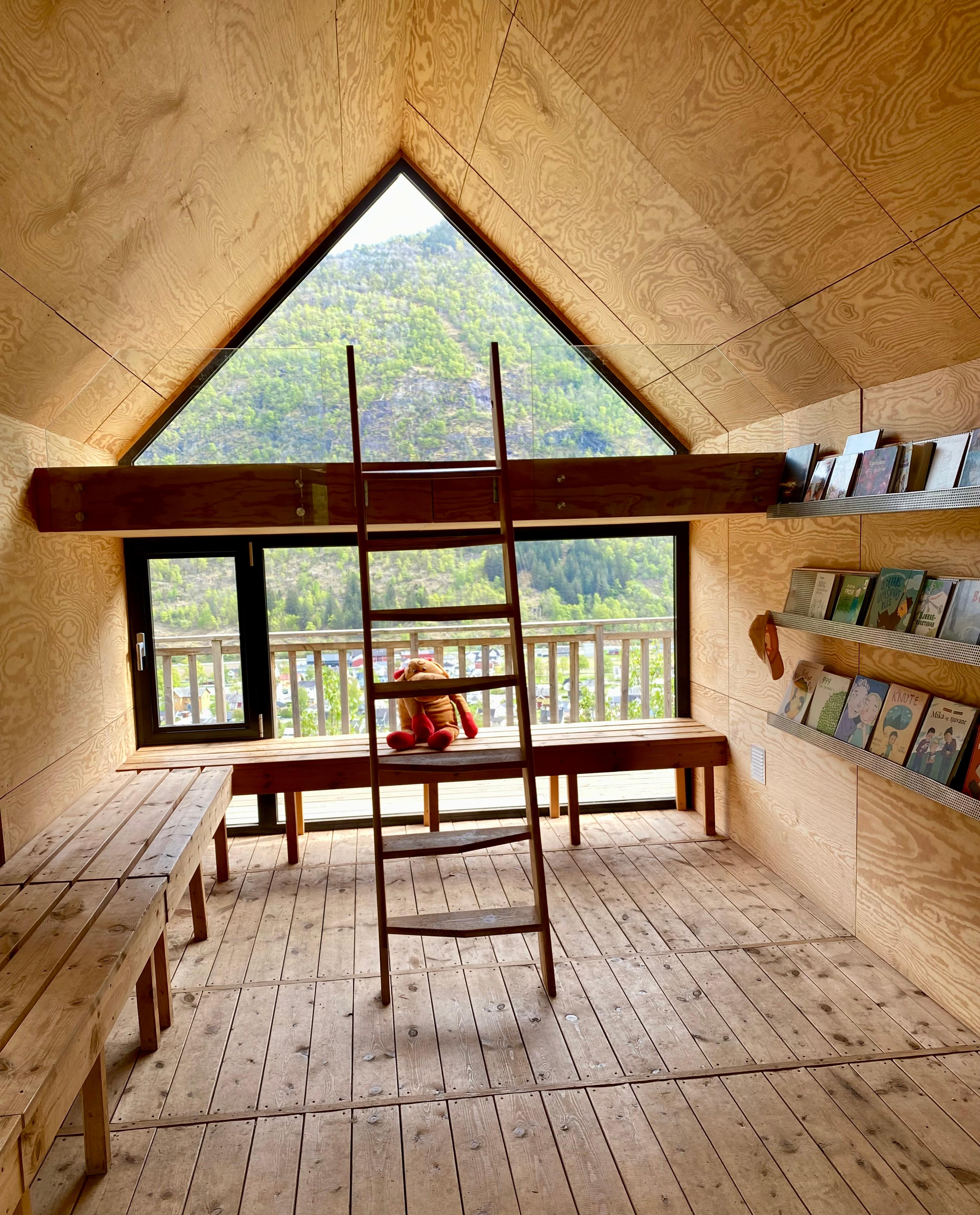 Inside the cabin there is a loft, ladder, seating and children's books