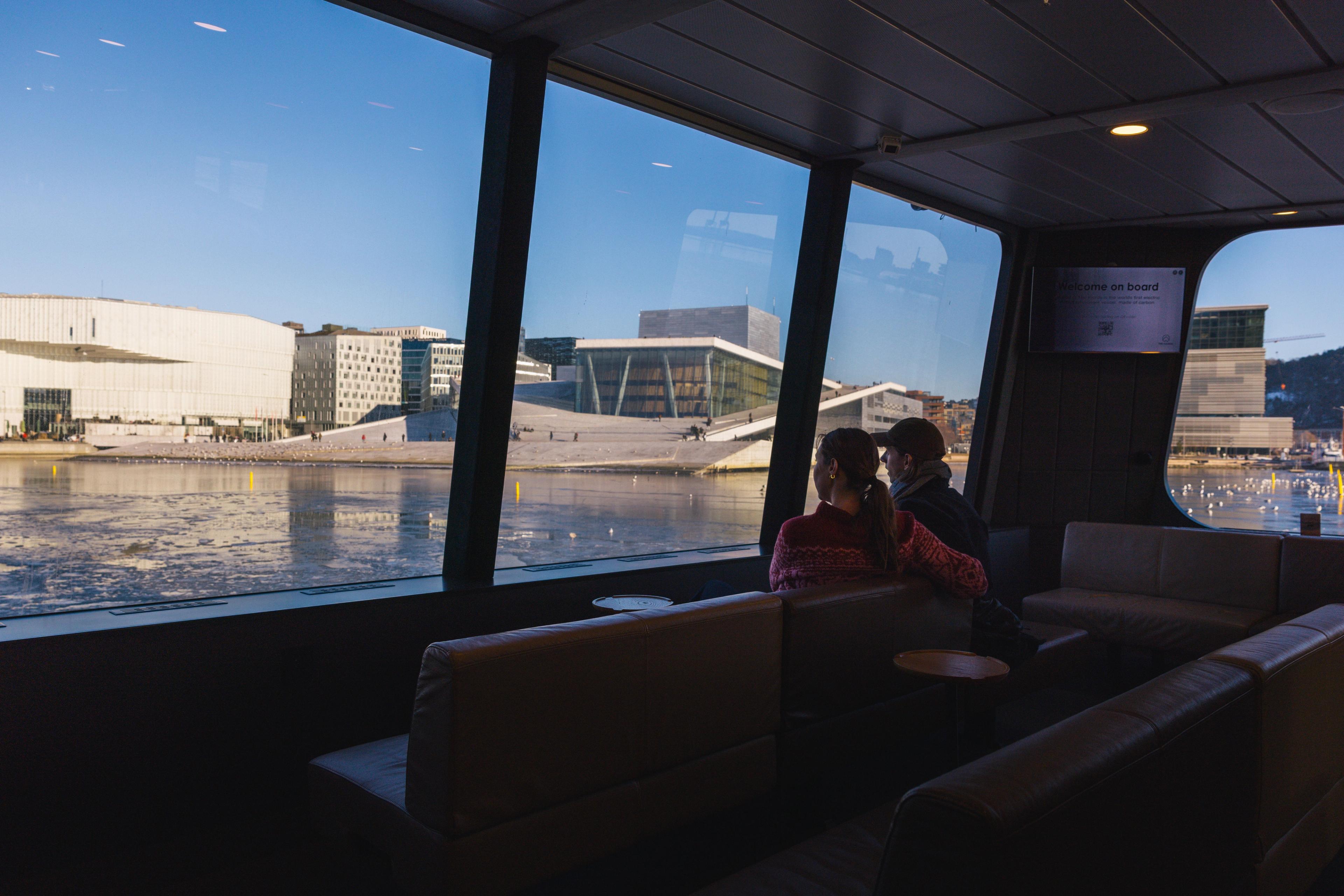 Tourists looking out at the Opera House from the fjord cruise