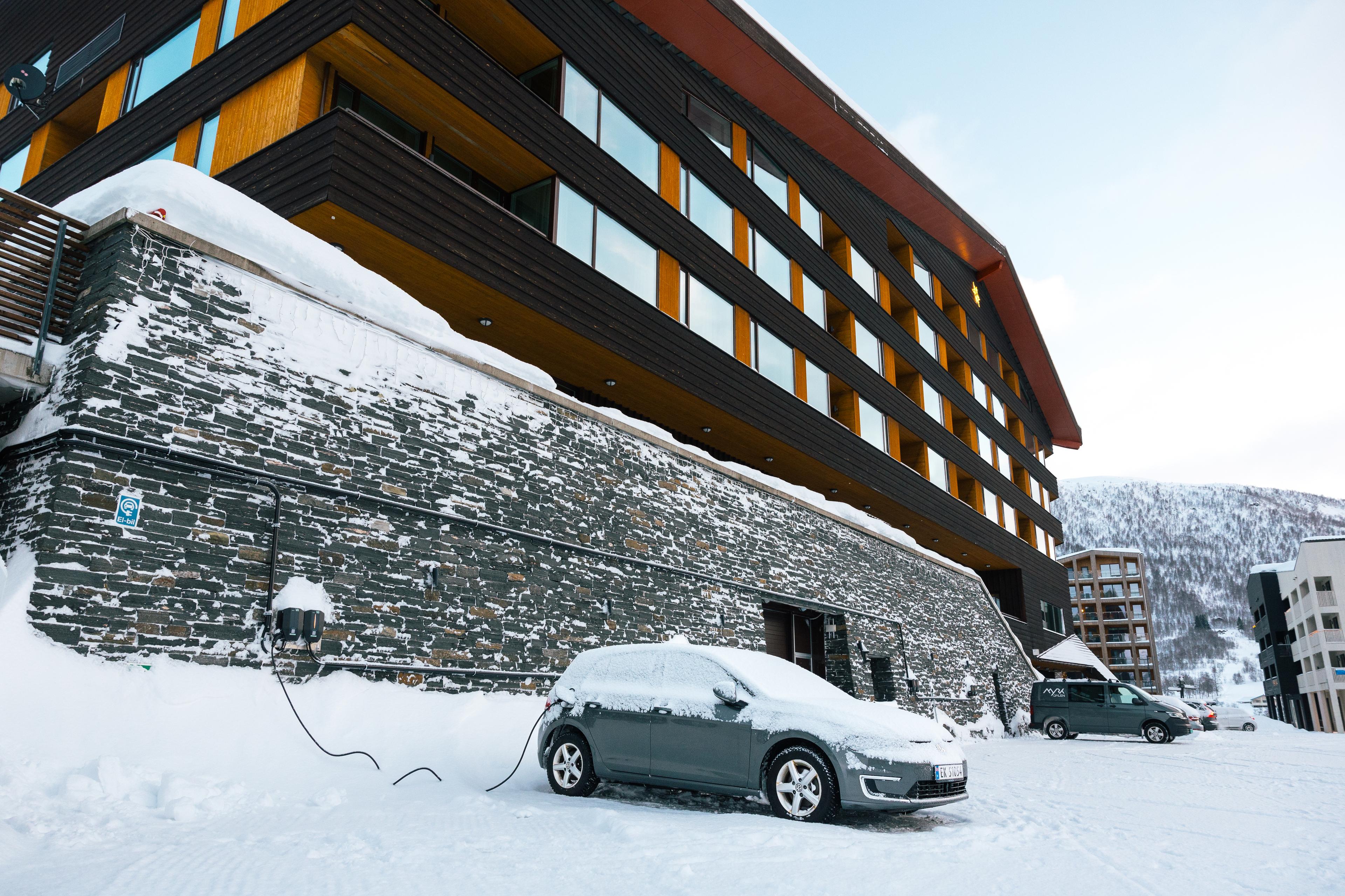 A car is connected to a charging station in front of Myrkdalen Hotel