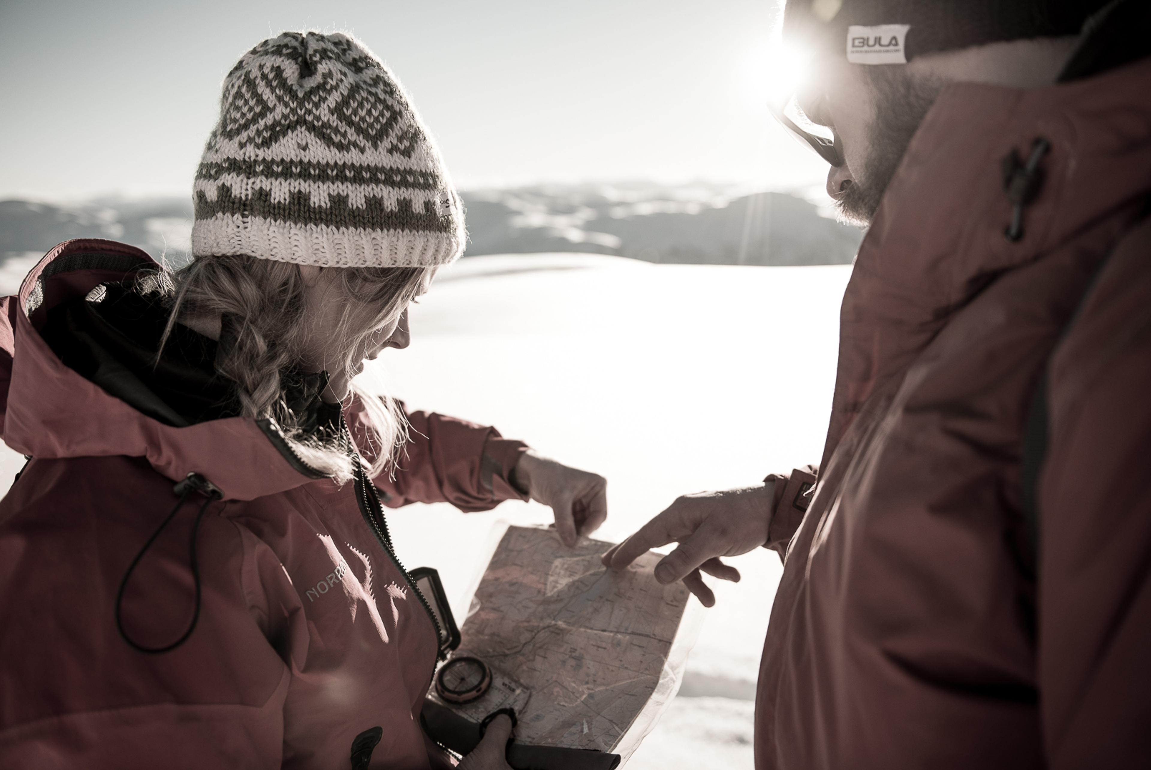  A couple uses a map and compass on a walk on a winter's day.