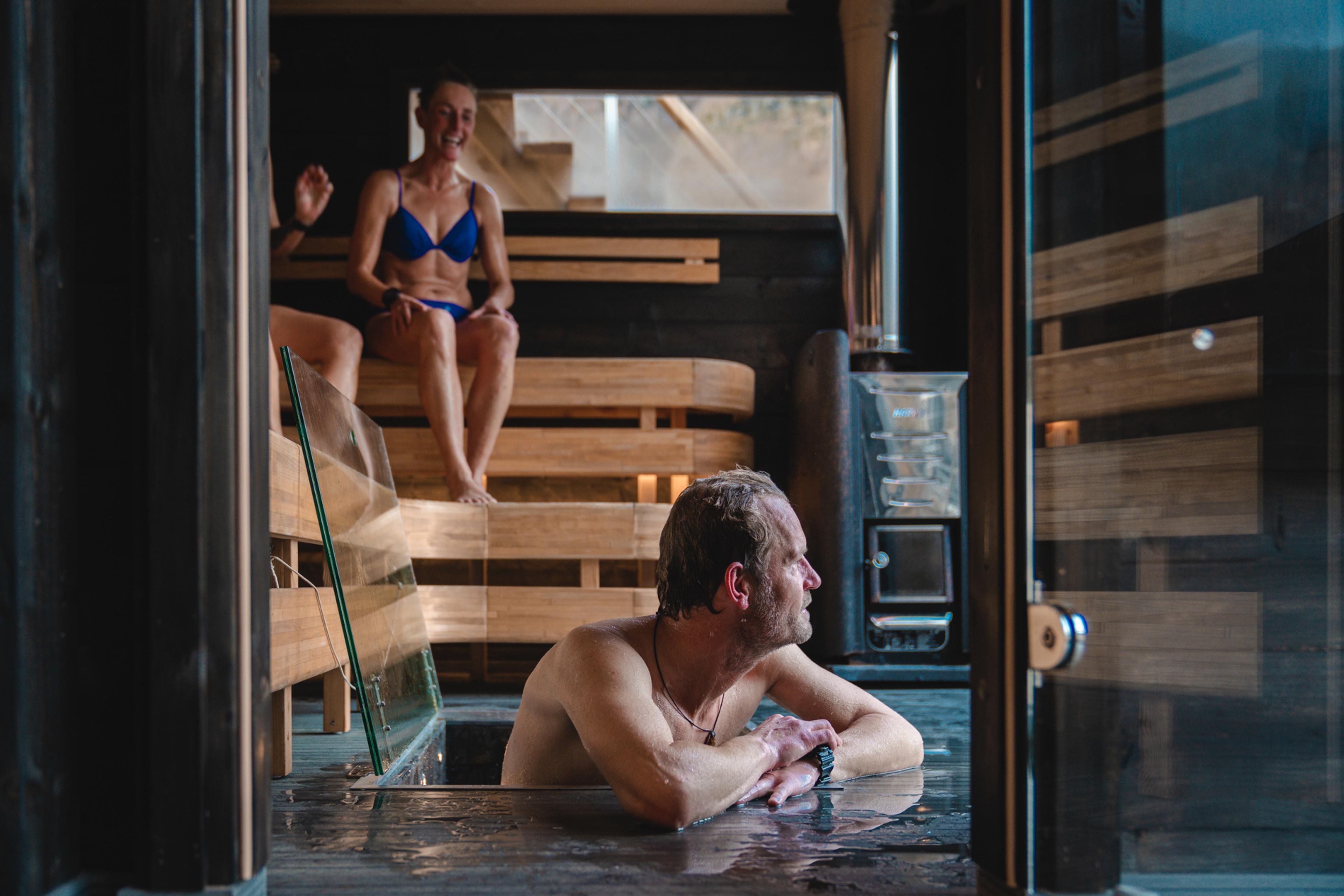 Friends relax in the fjord sauna and take a refreshing dip.