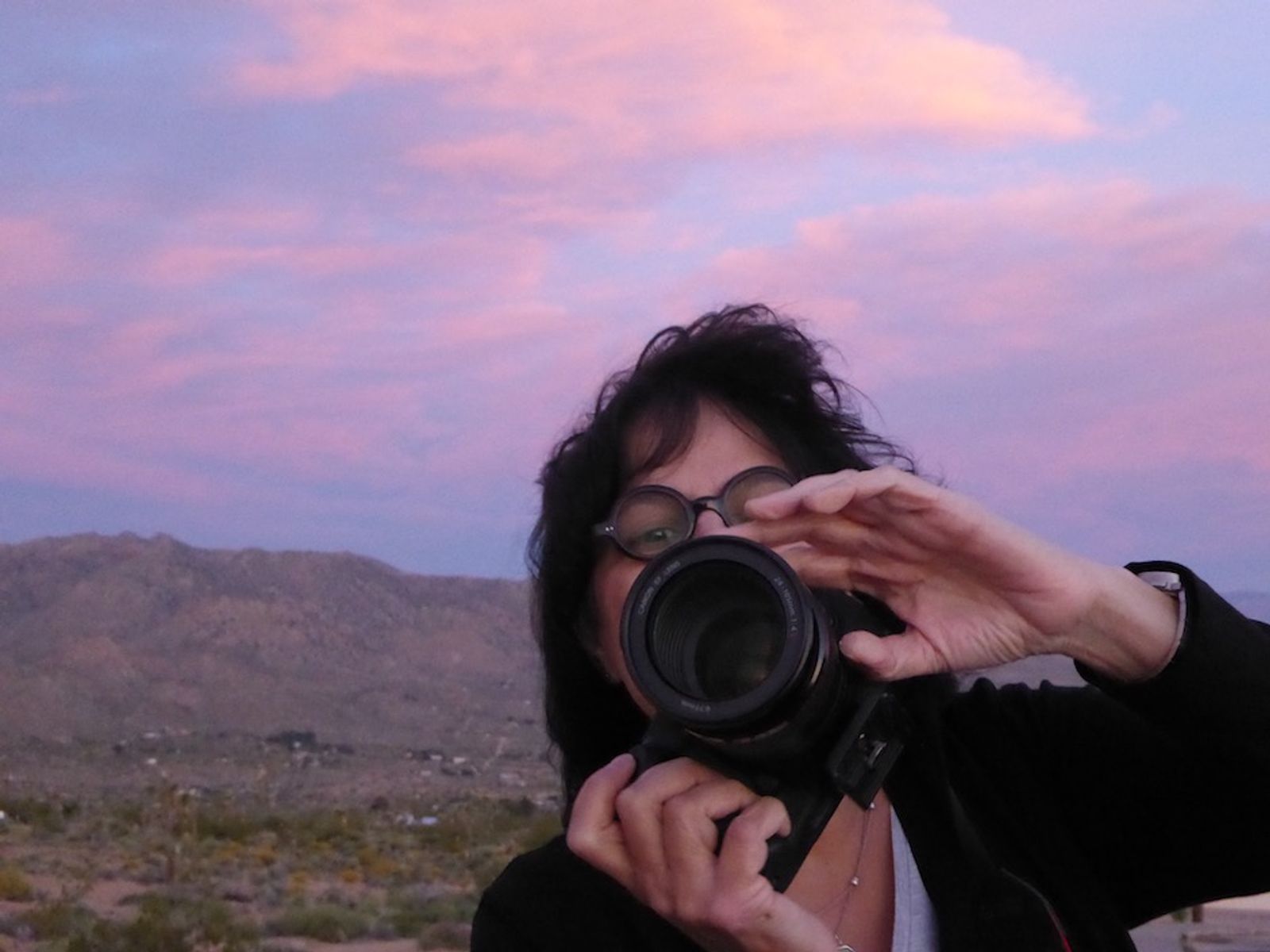 The artist Sadia Sadia photographing the landscape at dawn in Joshua Tree National Park, California.