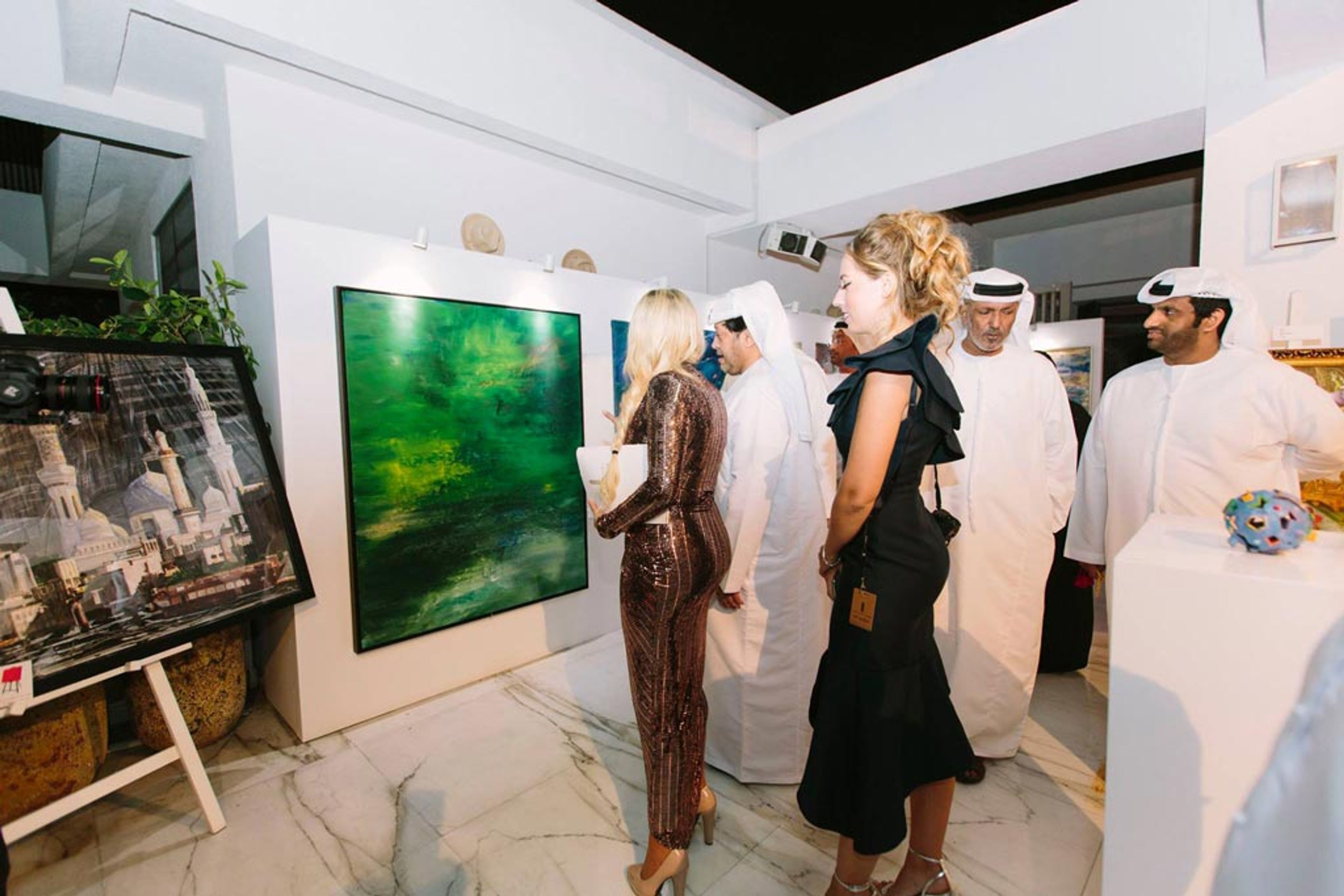 Rima Chahine with guests beside a painting at the Global Art Awards 2018, Dubai