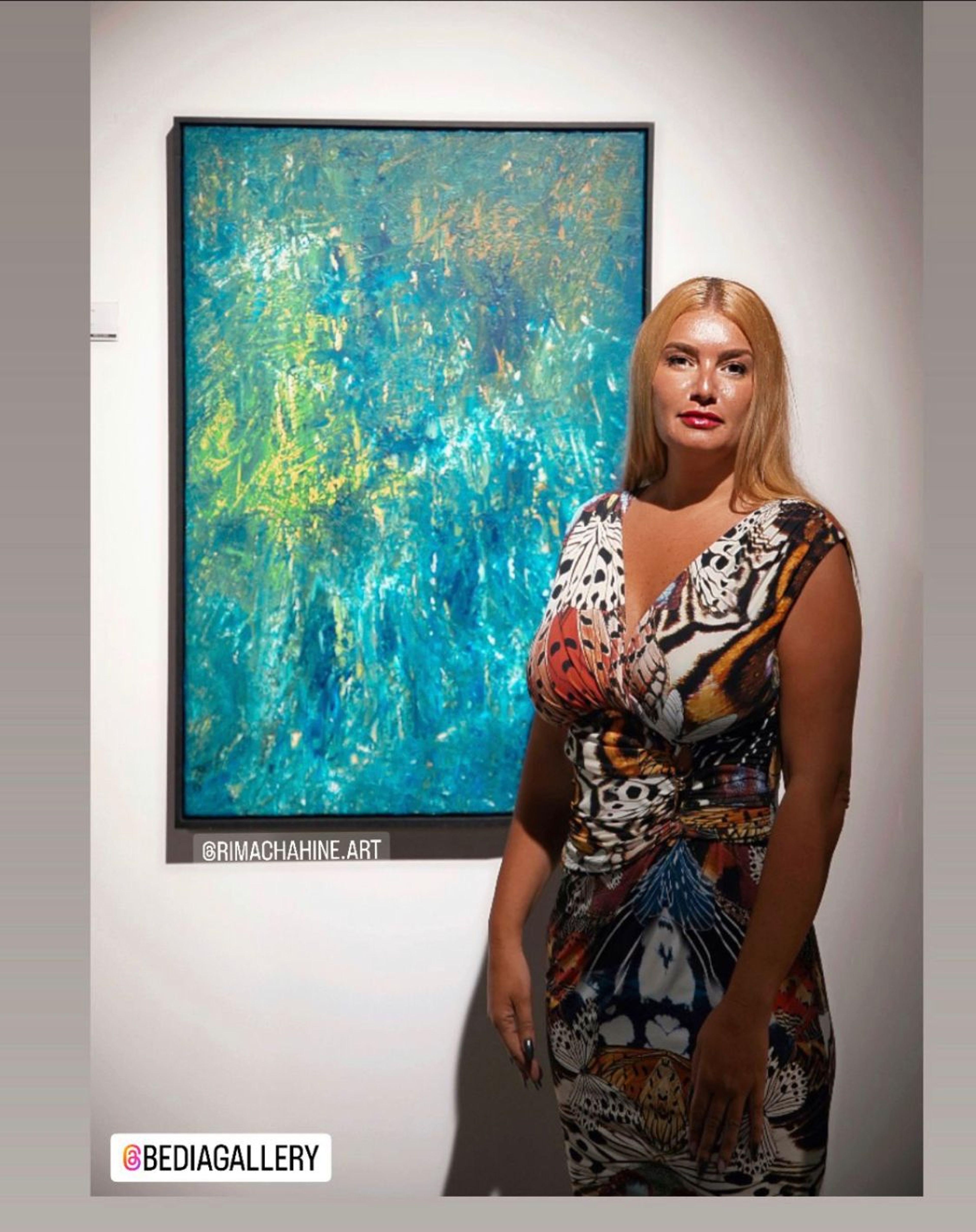 Rima Chahine beside a blue and green abstract painting at Spring Life, Al Khayat Avenue, Dubai