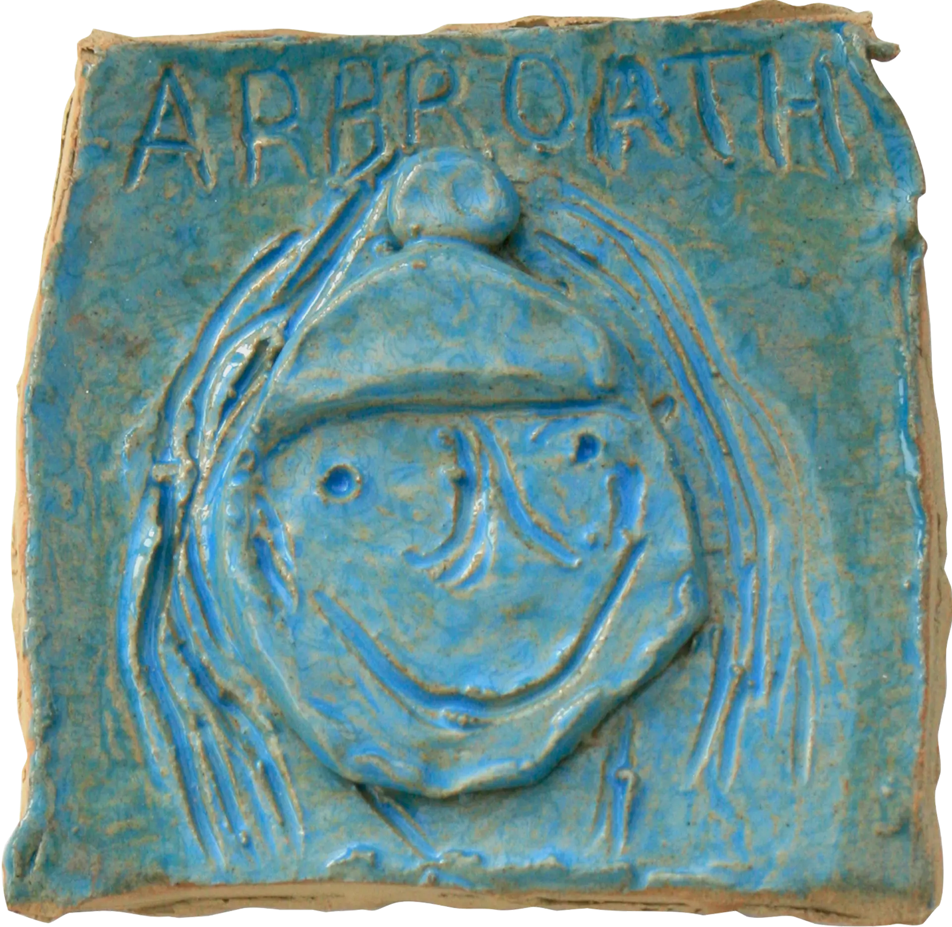 A blue glazed ceramic tile of Helen, a self portrait. She has a hat on and is smiling, written above her is ‘ARBROATH’