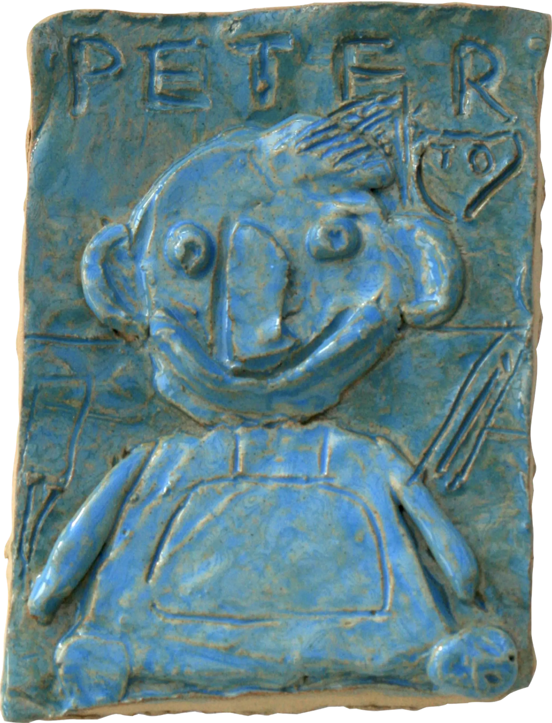 A blue glazed ceramic tile of Peter, by Helen. He is in a wheelchair. Above his portrait Helen has written his name, and has drawn the Arbroath football team logo