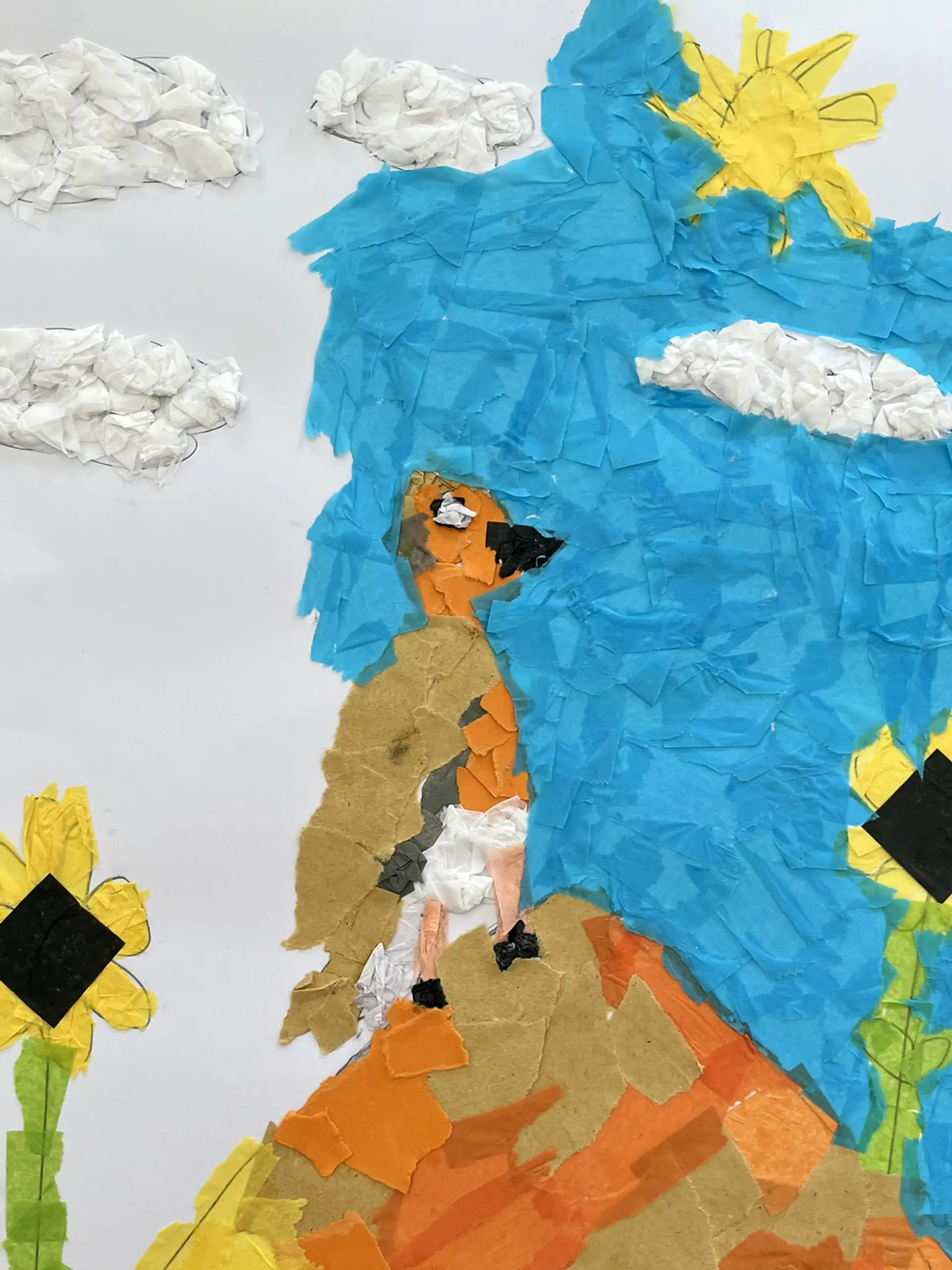 A tissue paper collage of a bird, standing on an orange and beige rock. The sky is blue with textured white clouds and a yellow sun. There are two yellow sunflowers in the foreground. 