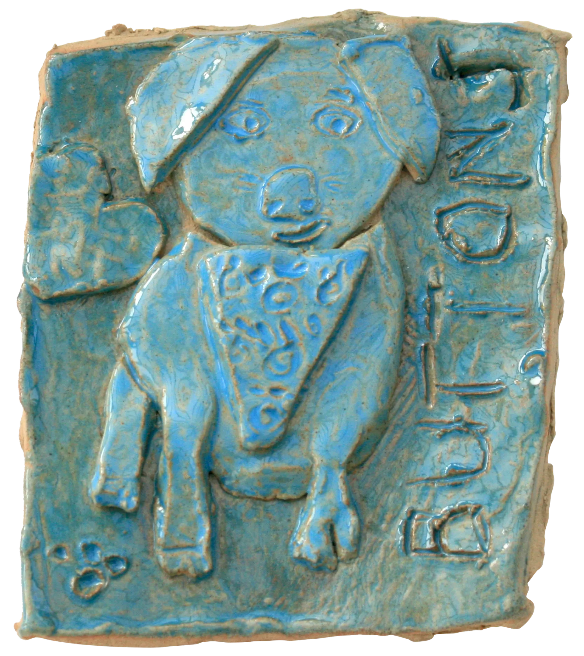 A blue glazed ceramic tile of Tasha’s pet dog, Buttons. Buttons is wearing a bandana around his neck, and a love heart has been added to the background on the left hand side of the tile