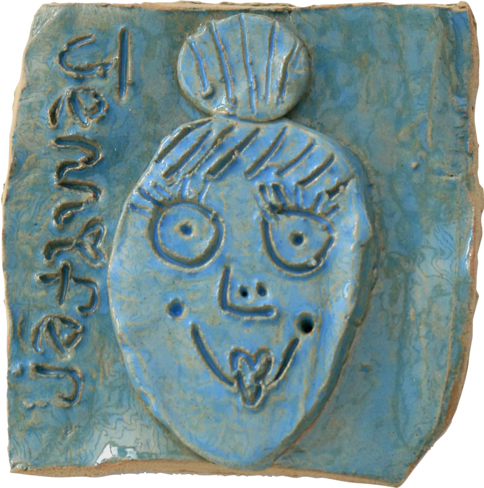 A blue glazed ceramic tile of Jessica’s sister Jennifer. She has her hair in a bun on top of her head, and is smiling. ‘Jennifer’ is written down the side of the tile, with a love heart instead of a dot on top of the letter i. 