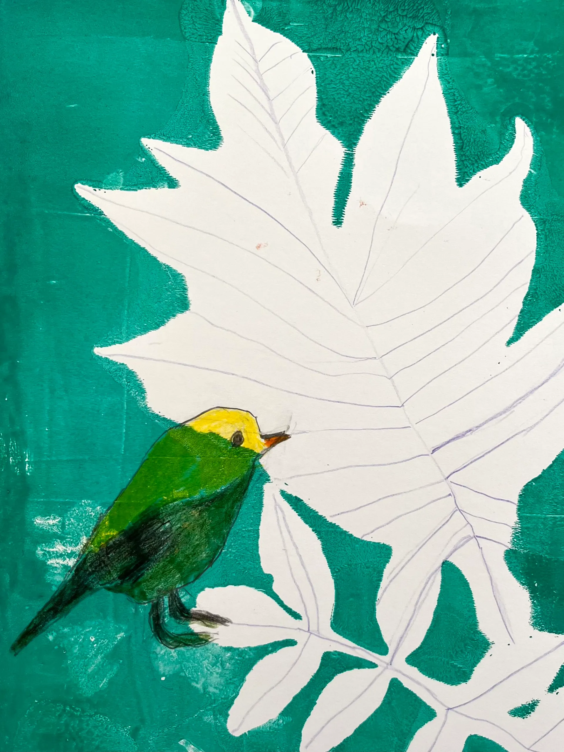 A leaf has been used to create a print with green ink. A yellow bird has been drawn with coloured pencil over the print. 