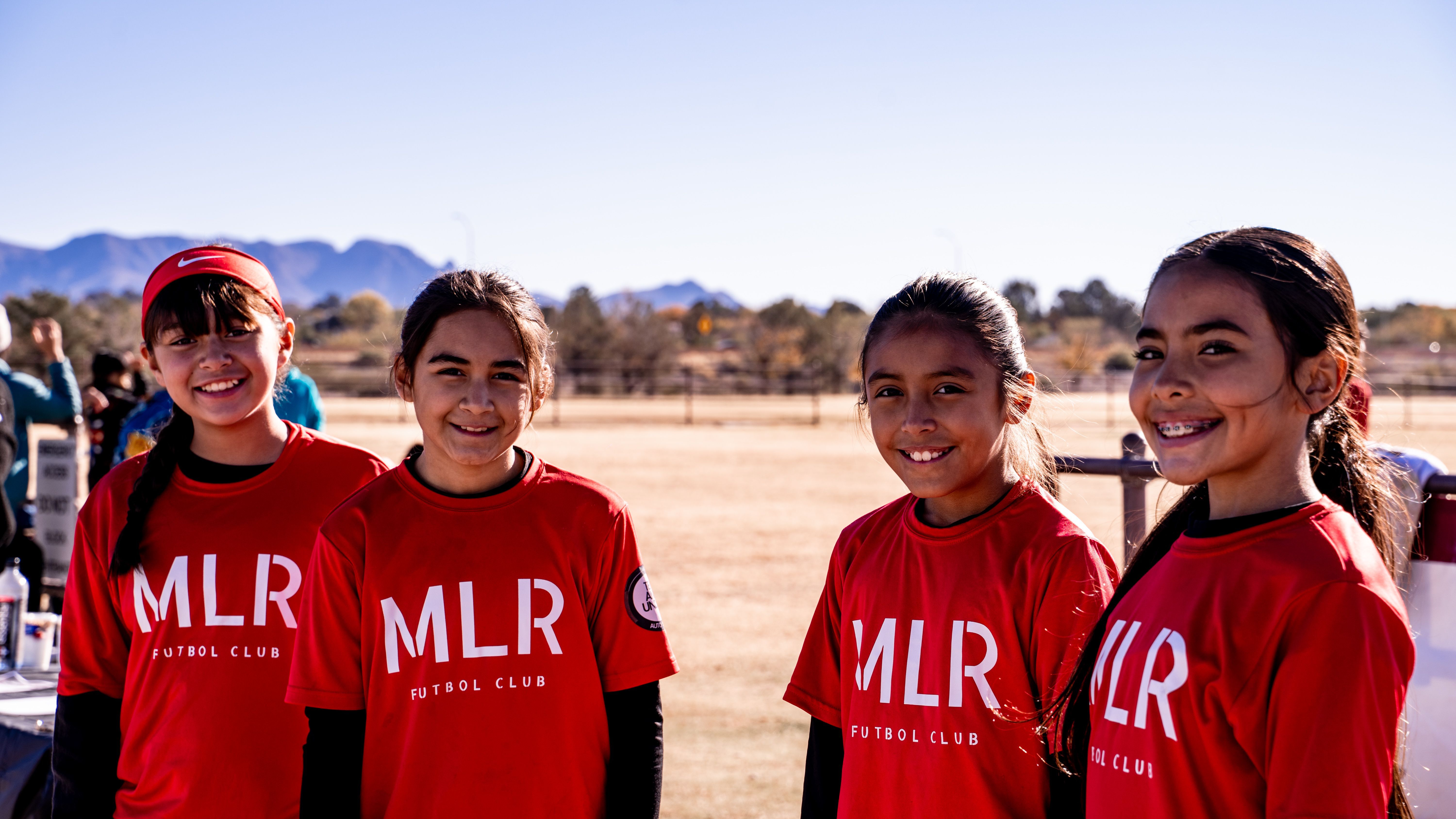Five Girls U14 players lined up, the Organ Mountains behind them