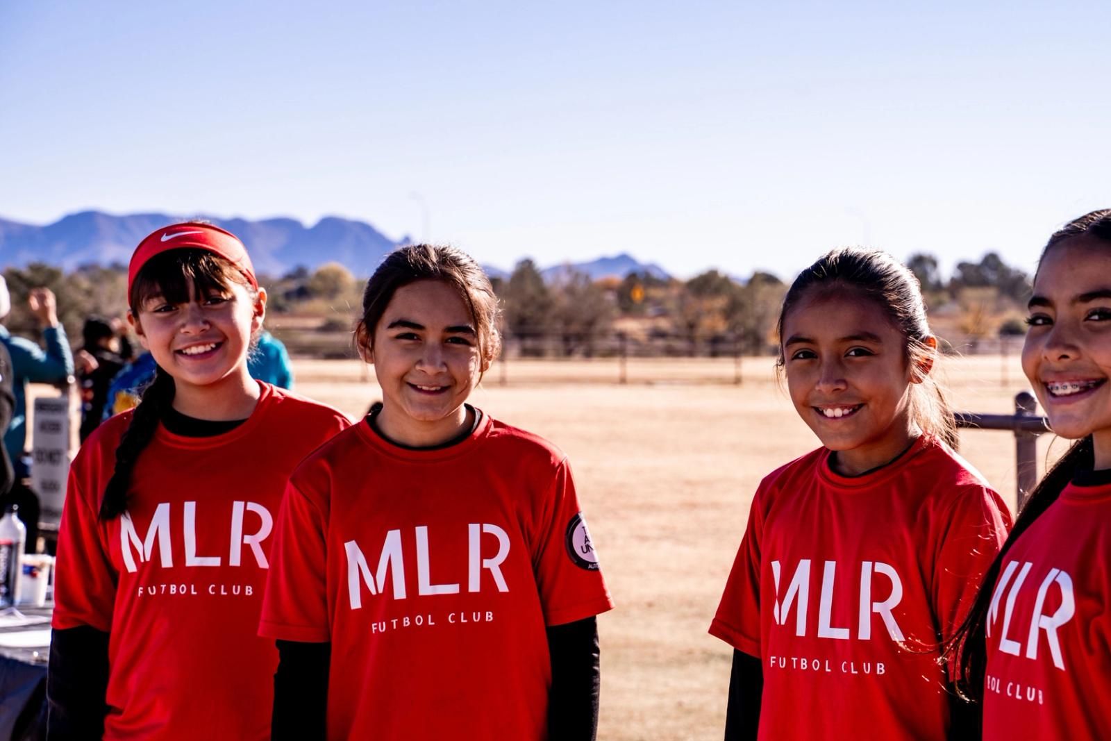 Five Girls U14 players lined up, the Organ Mountains behind them