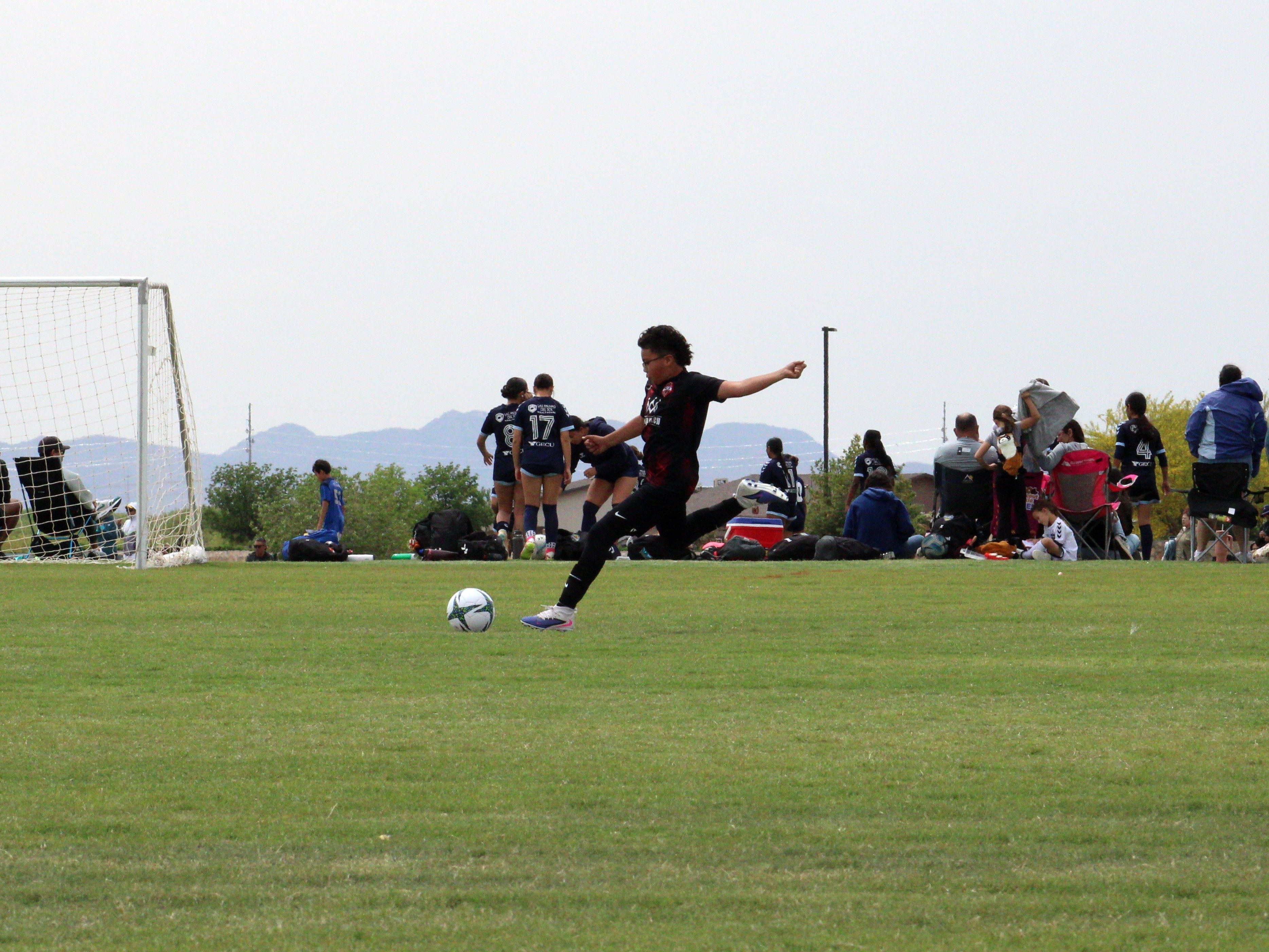 A shot on goal during a Copa de Campeones game, mountains in the distance