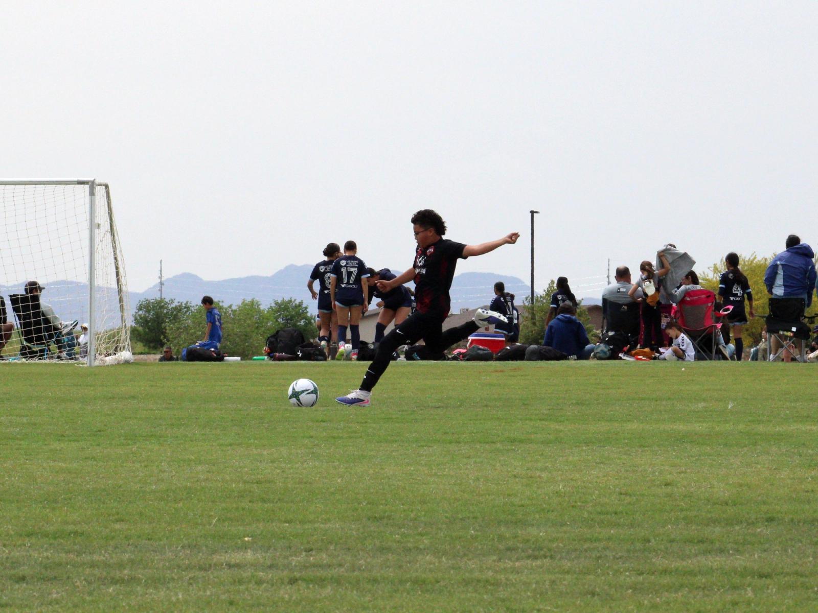 A shot on goal during a Copa de Campeones game, mountains in the distance