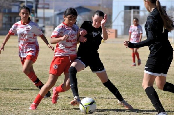 Girls U12 players chasing the ball