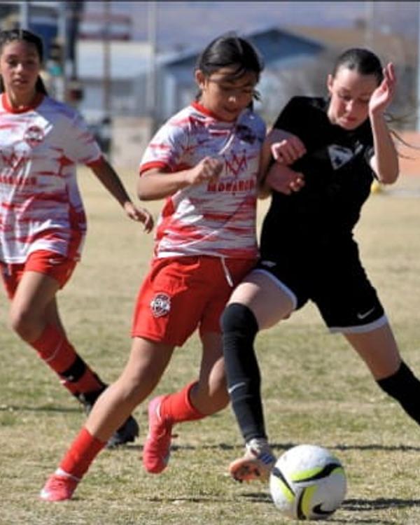 Girls U12 players chasing the ball