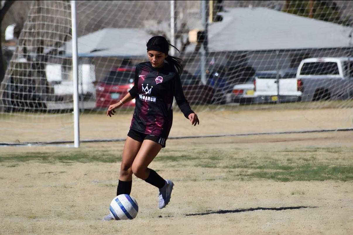 Girls player with the ball in front of goal
