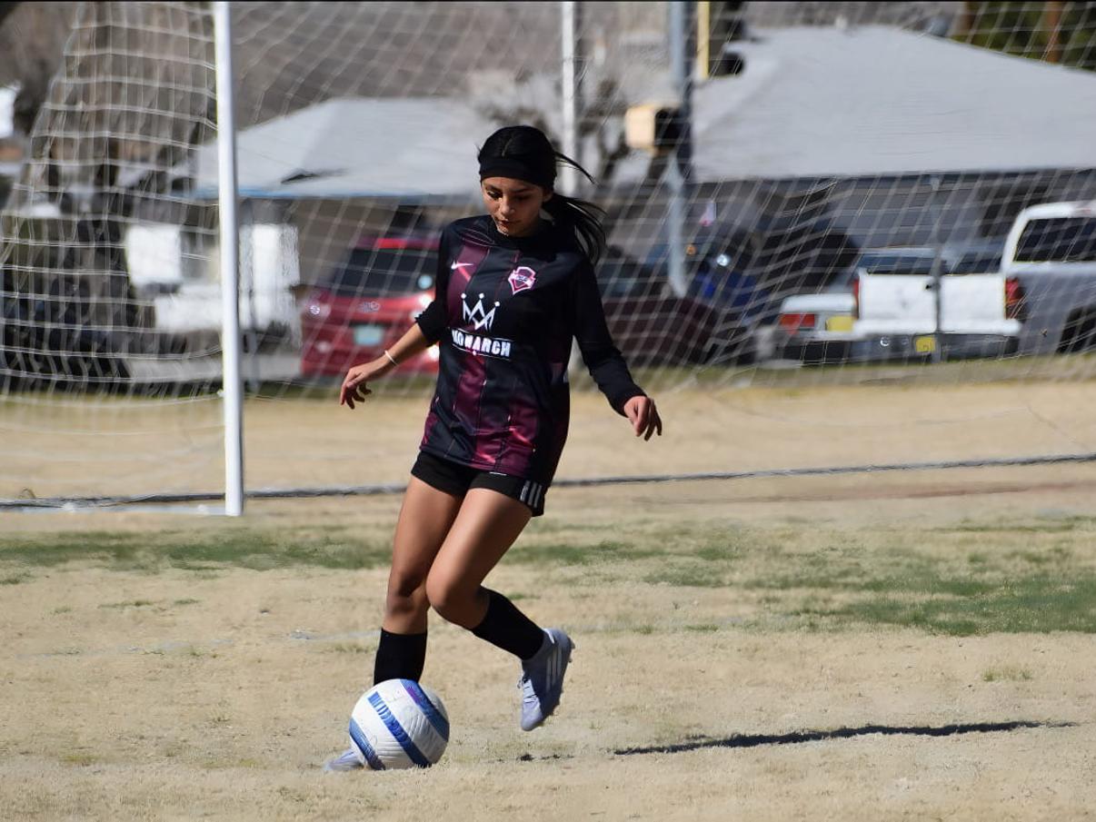 Girls player with the ball in front of goal