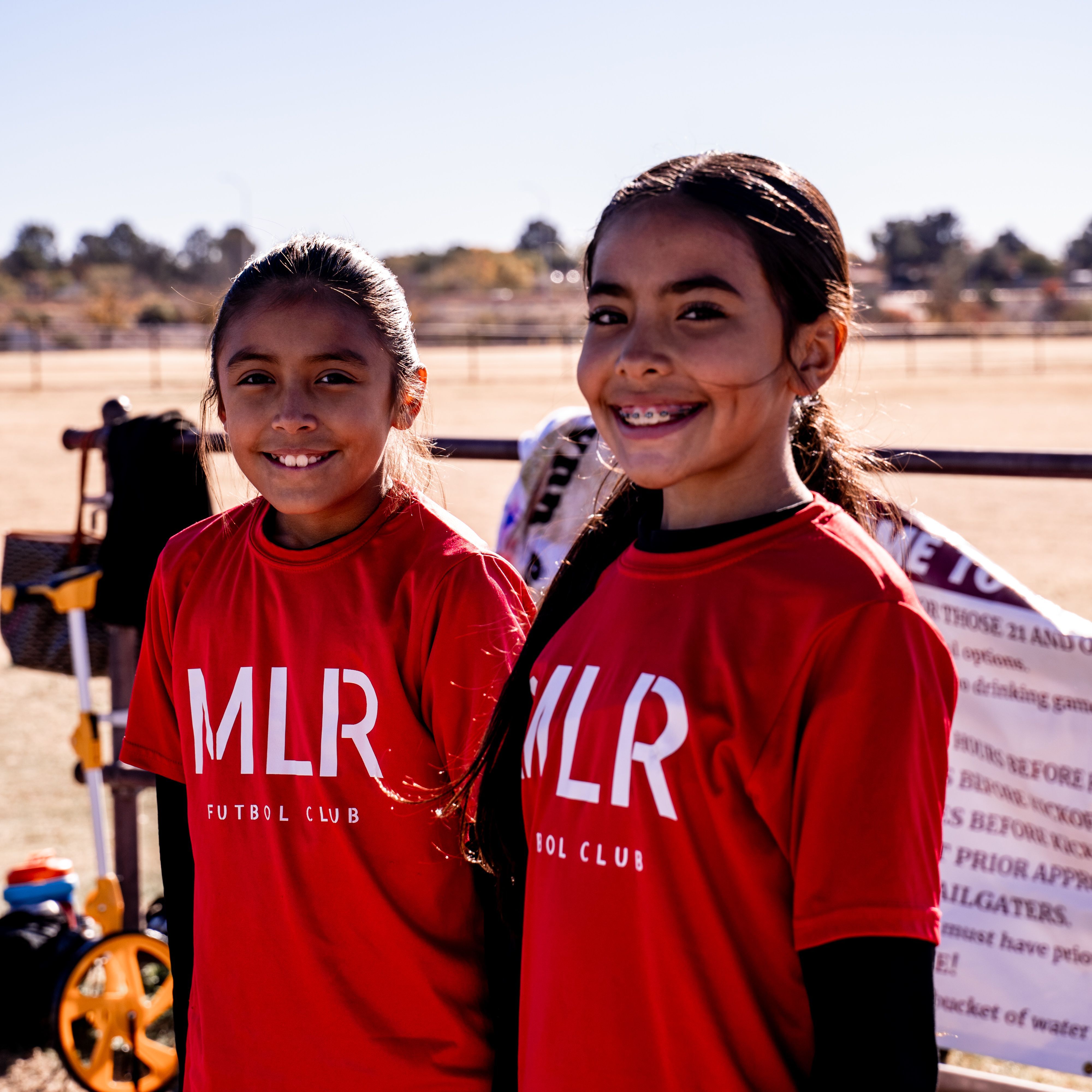 Two Girls U14 players smiling on the sideline