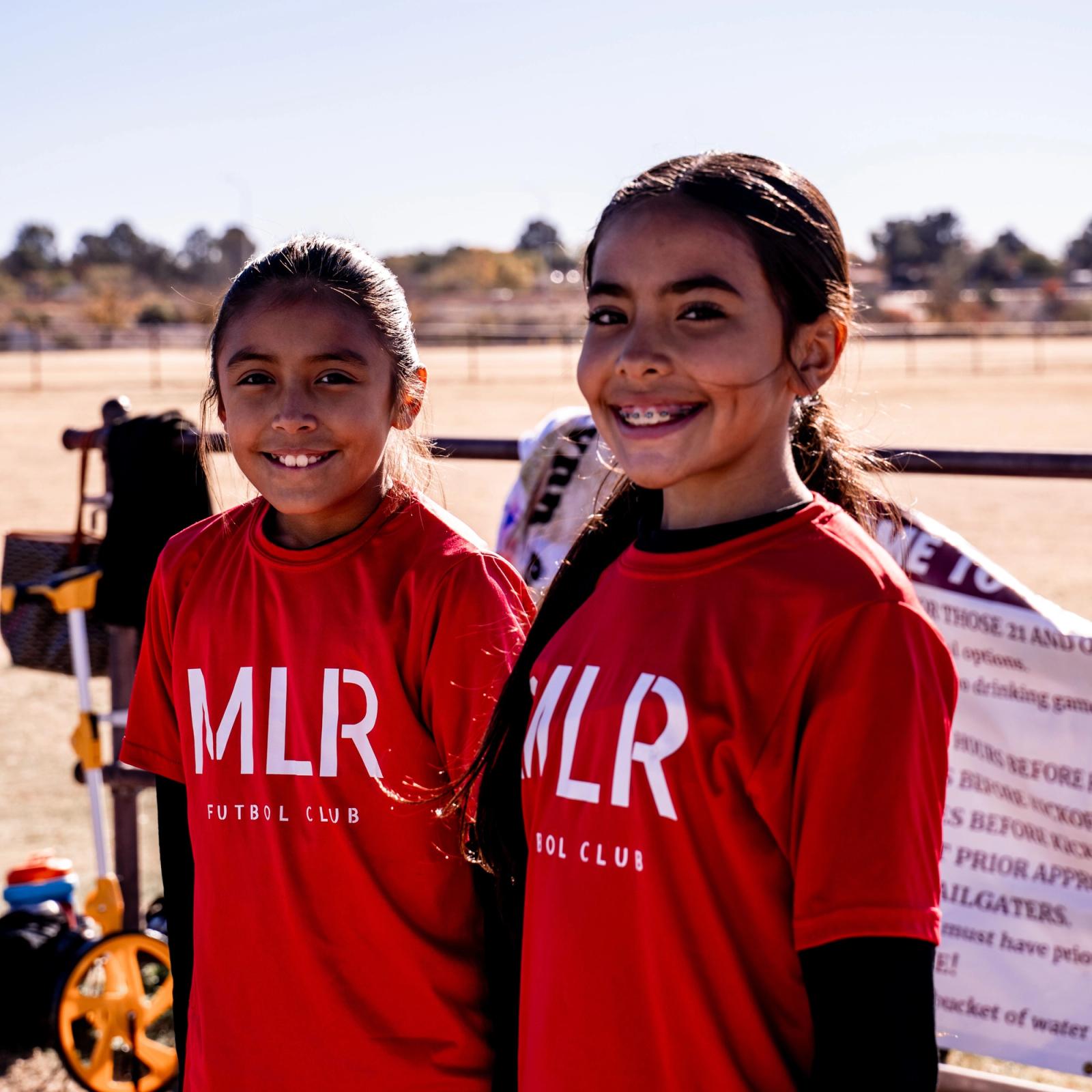 Two Girls U14 players smiling on the sideline