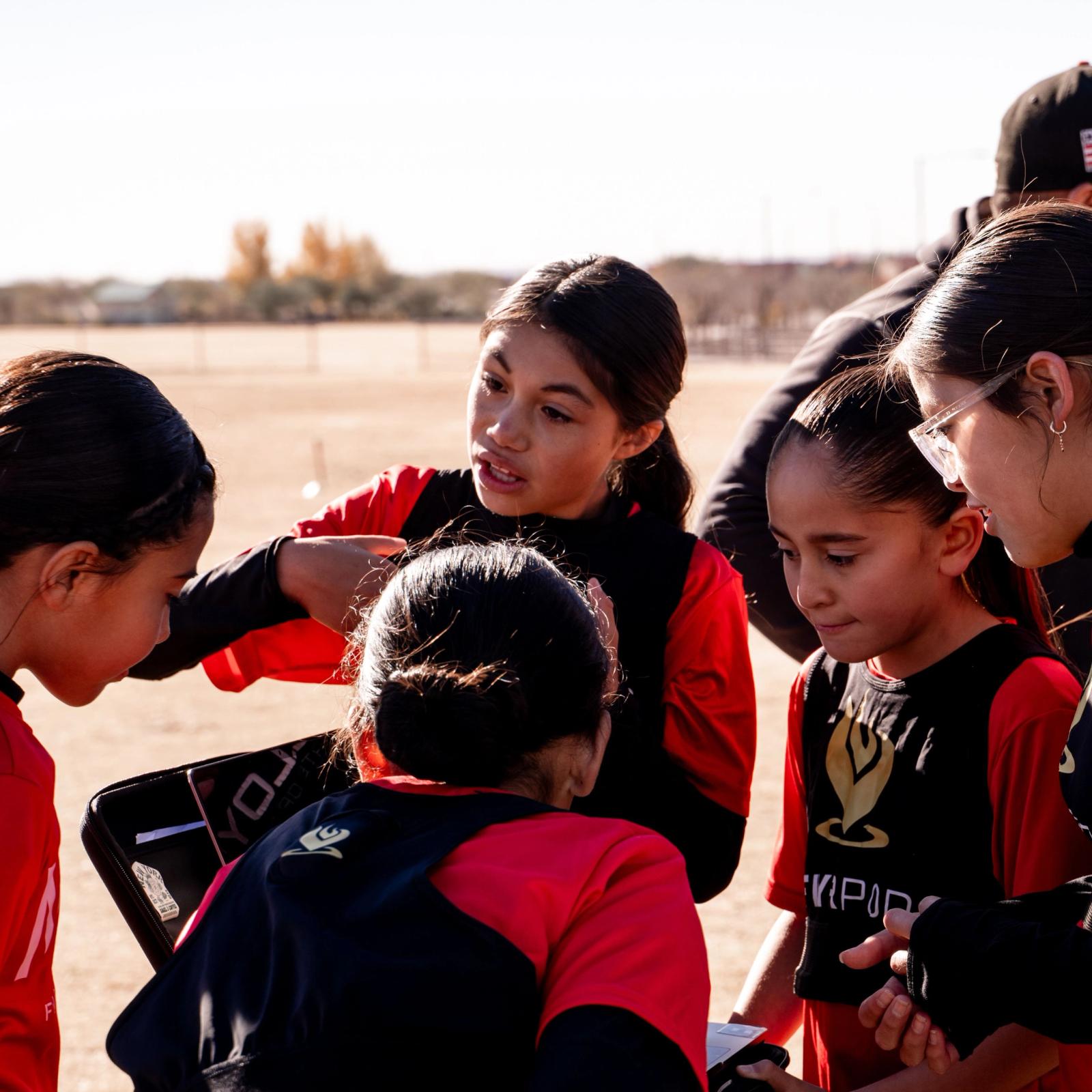 Girls U14 huddle, hands in before kickoff