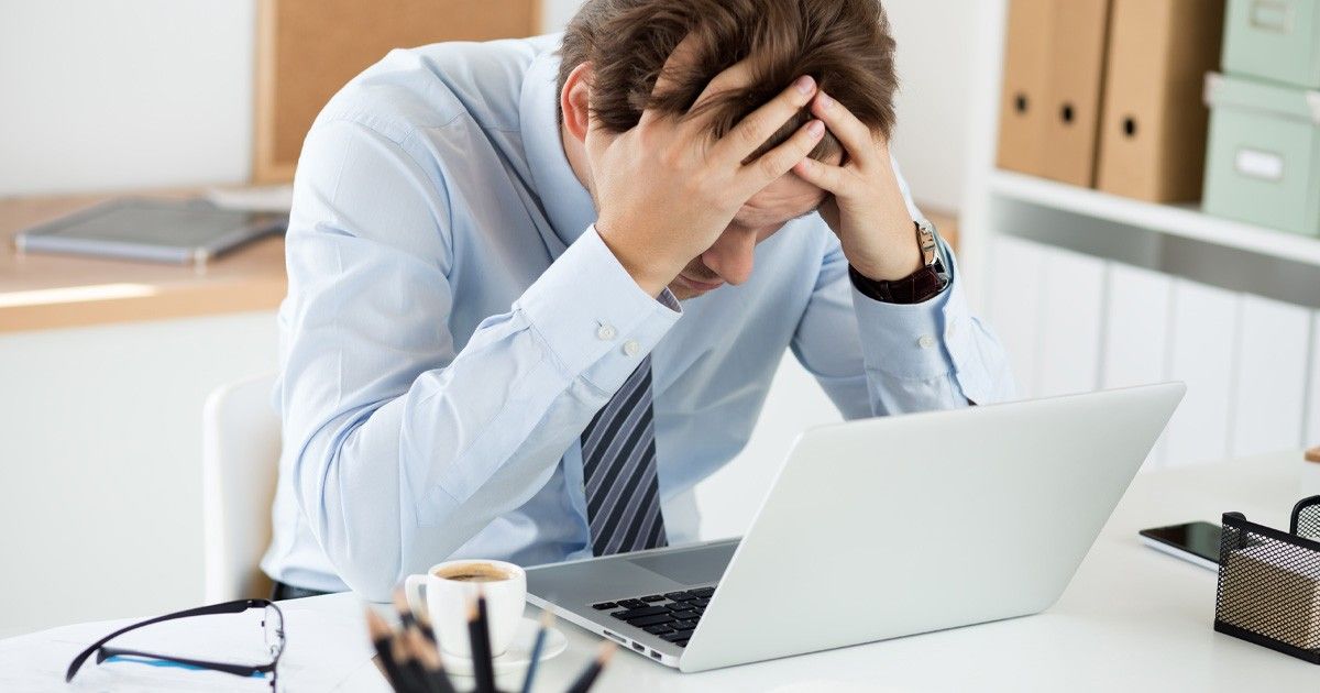 A professional at a desk taking a calm, mindful pause, representing the balance between workplace productivity and stress management