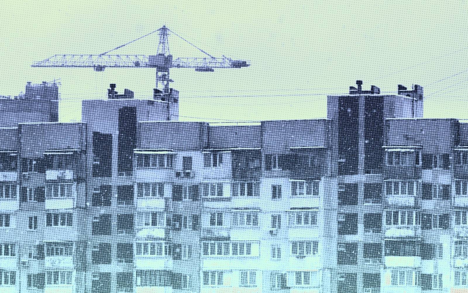 Багатоповерхові житлові будинки та будівельний кран на світло-блакитному тлі.