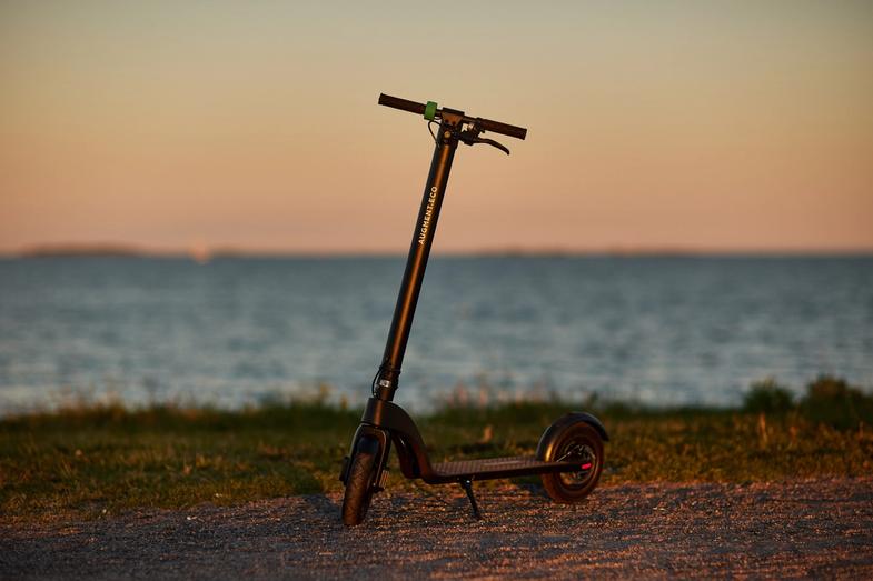 Vista laterale dell'e-scooter sulla spiaggia di sera