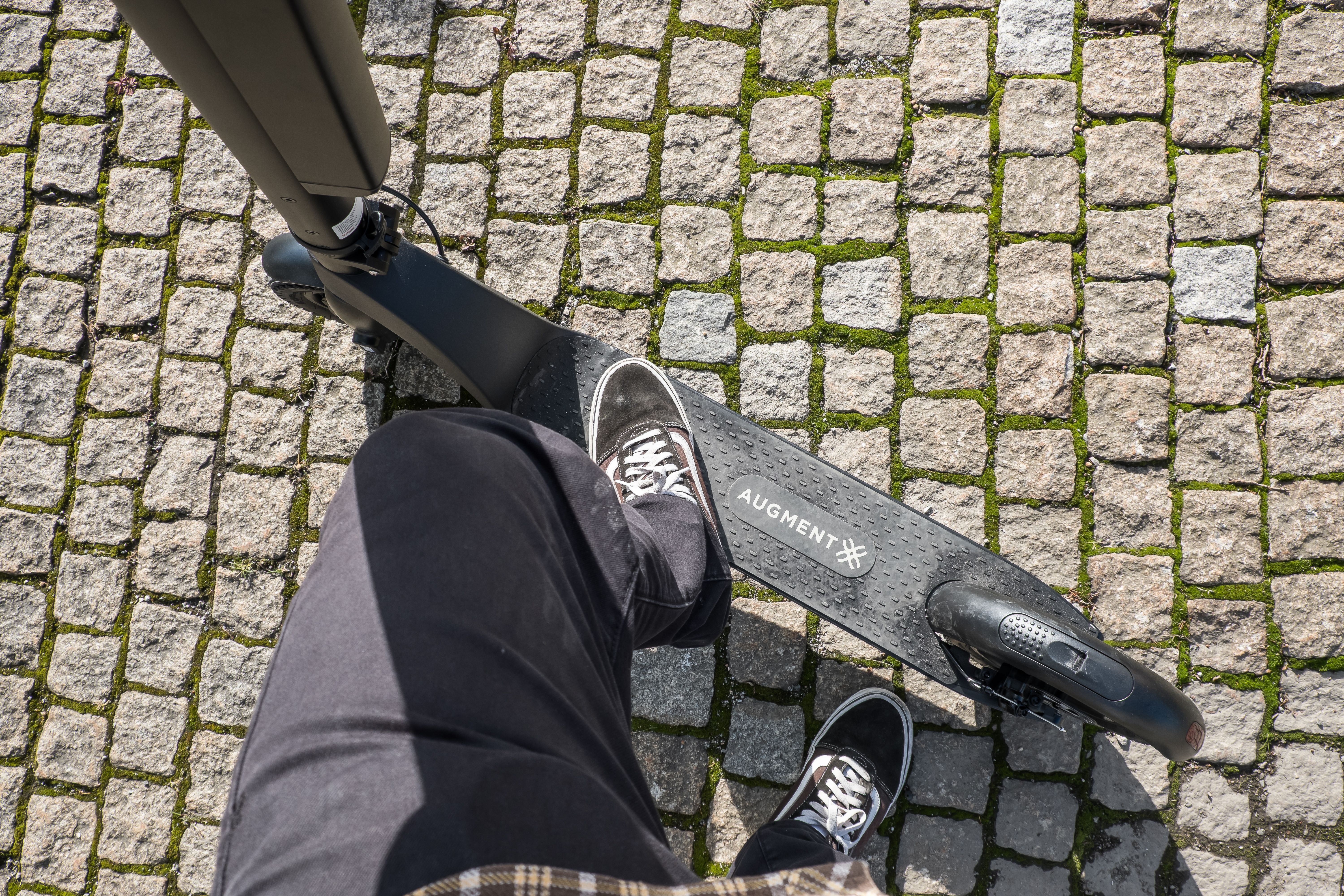 En Augment-elrullator ovanifrån på kullerstensgatan