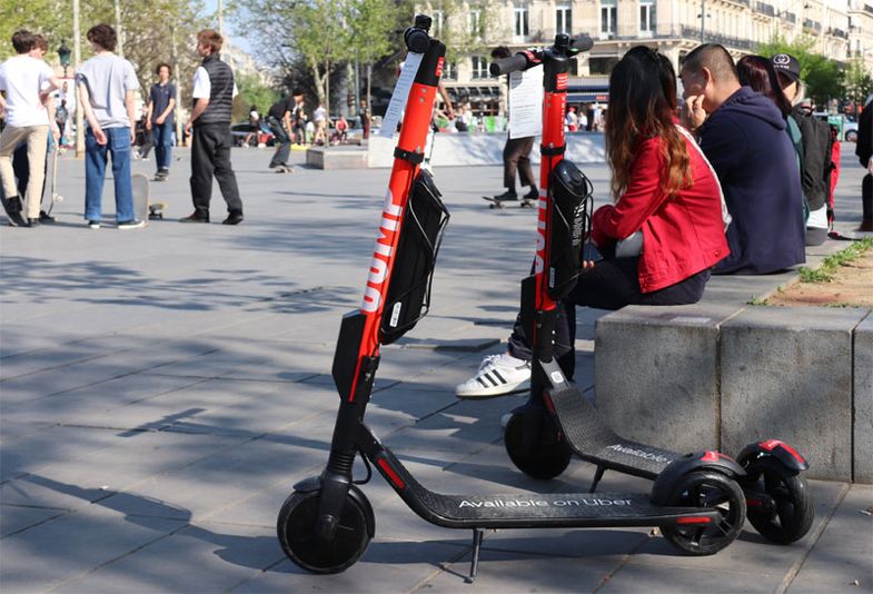 Deux scooters électriques en libre-service dans une rue.