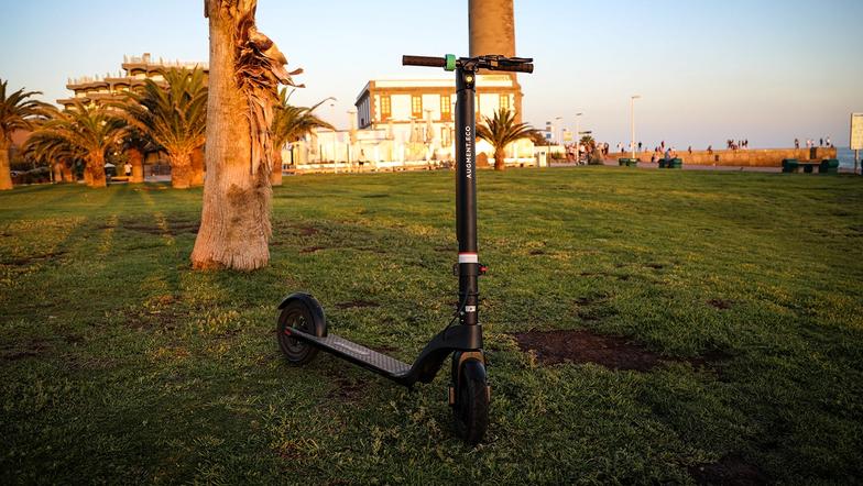 Vue de face d'un Augment e-scooter sur une pelouse au coucher du soleil