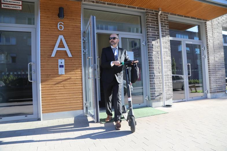 A man leaving from his home with an Augment e-scooter