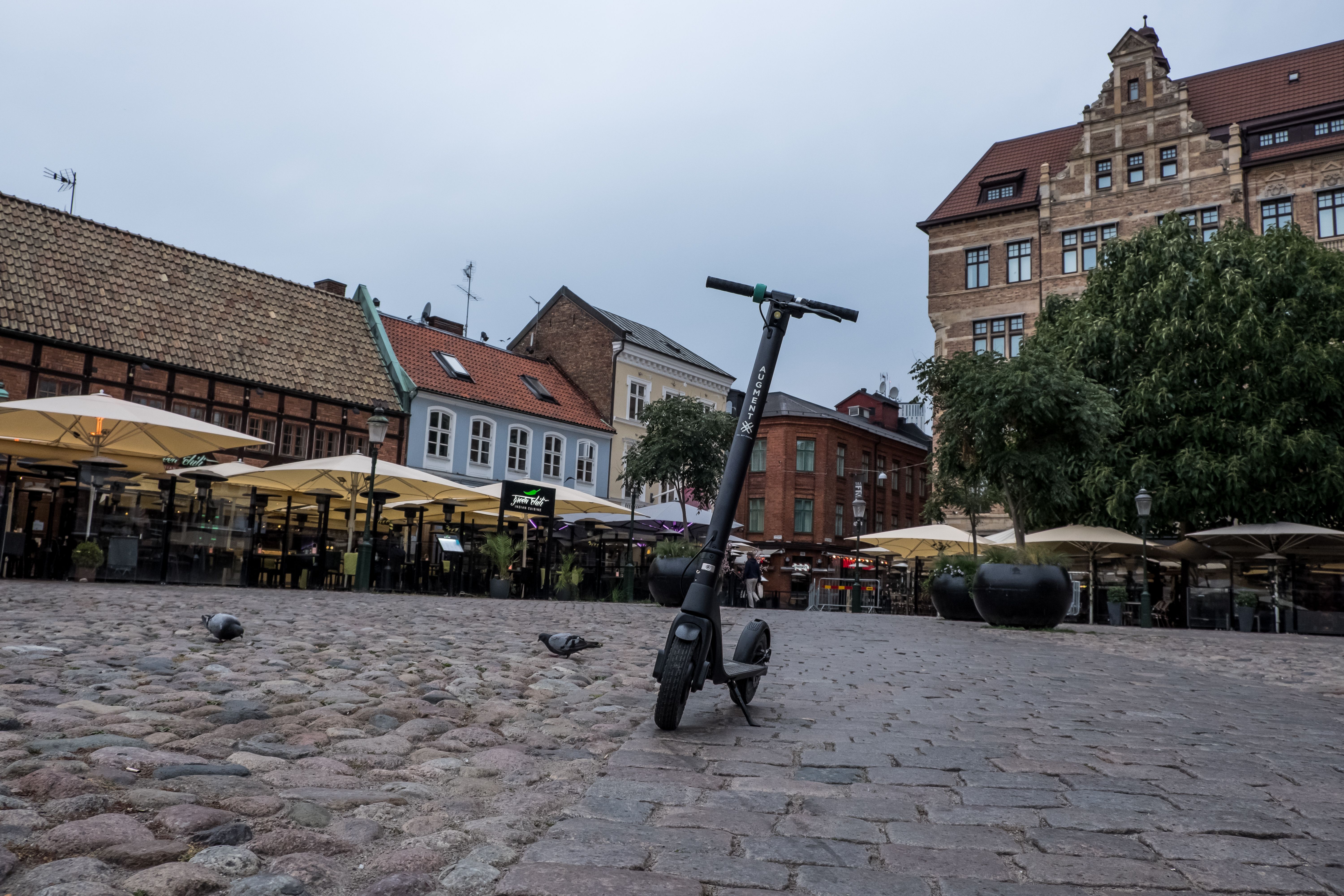 Framsidan av en Augment-cykelmotorcykel på en kullerstensgata en regnig dag