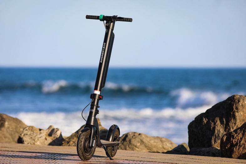 Front view of an Augment e-scooter with sea on background