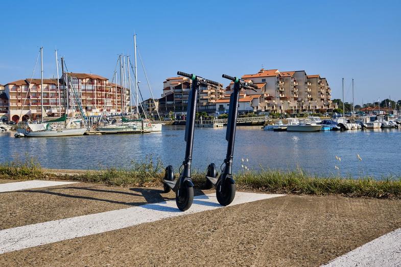 Deux scooters électriques Augment devant le port de la ville.